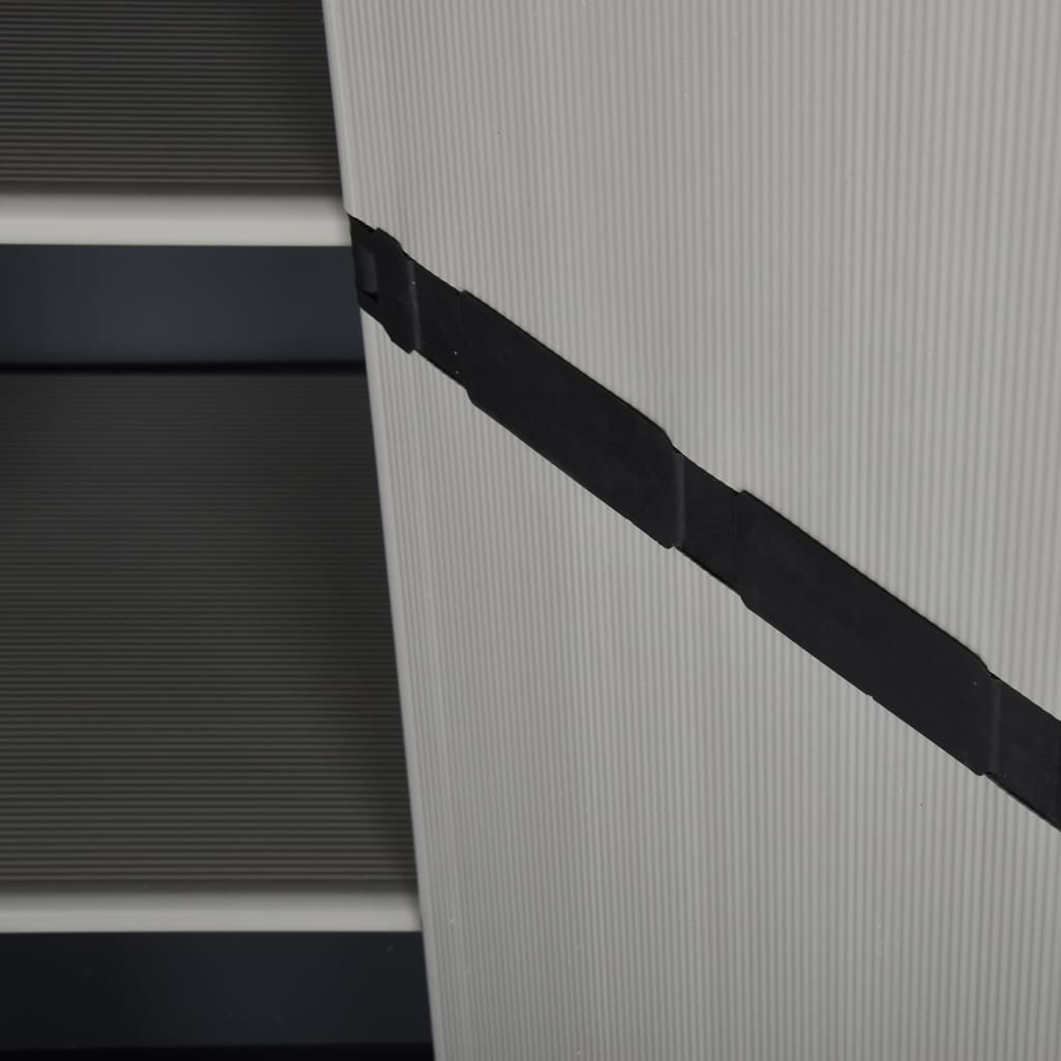 Ein weißer, an der Wand montierter Schrank mit Glastüren, der Bücher und Deko zeigt.