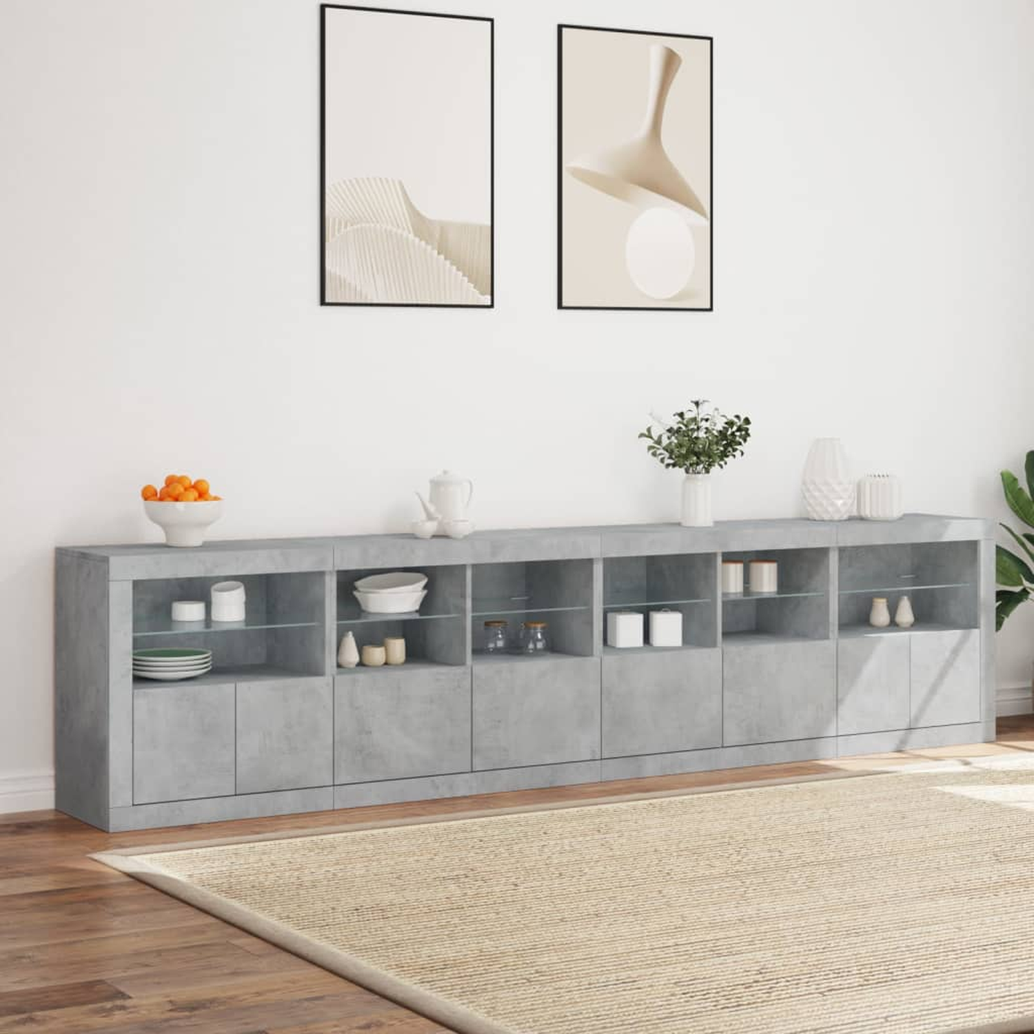Ein grauer Schrank mit Glastüren, Vasen und Dekoration, auf einem beigefarbenen Teppich, mit Bildern an der Wand.