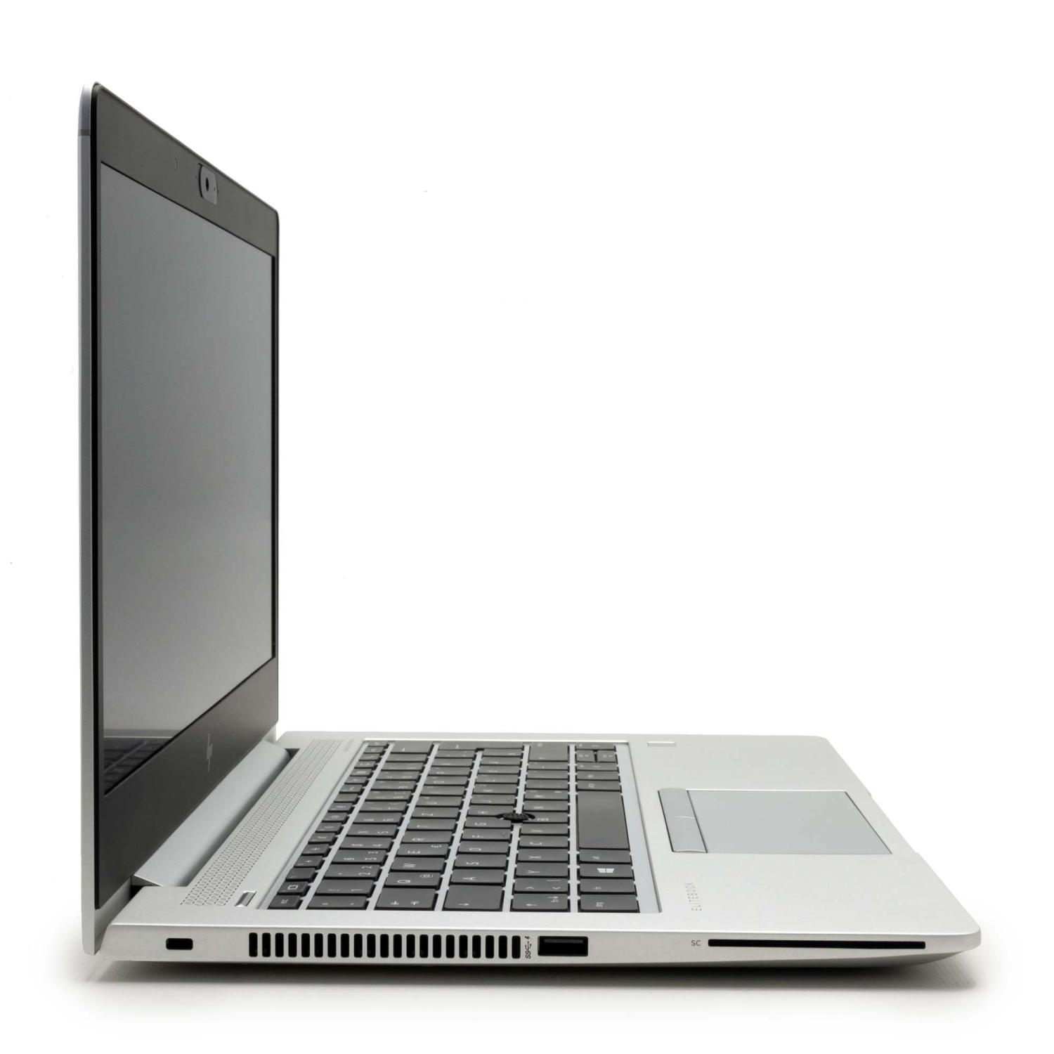 Laptop im Profil, silberfarben, geöffnet. Tastatur sichtbar, Bildschirm an, vor weißem Hintergrund.