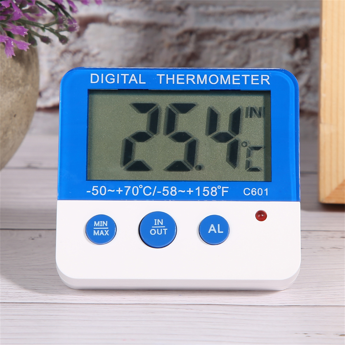 Ein digitales Thermometer zeigt 25,4 Grad Celsius an. Es hat Knöpfe und einen weißen Rahmen.