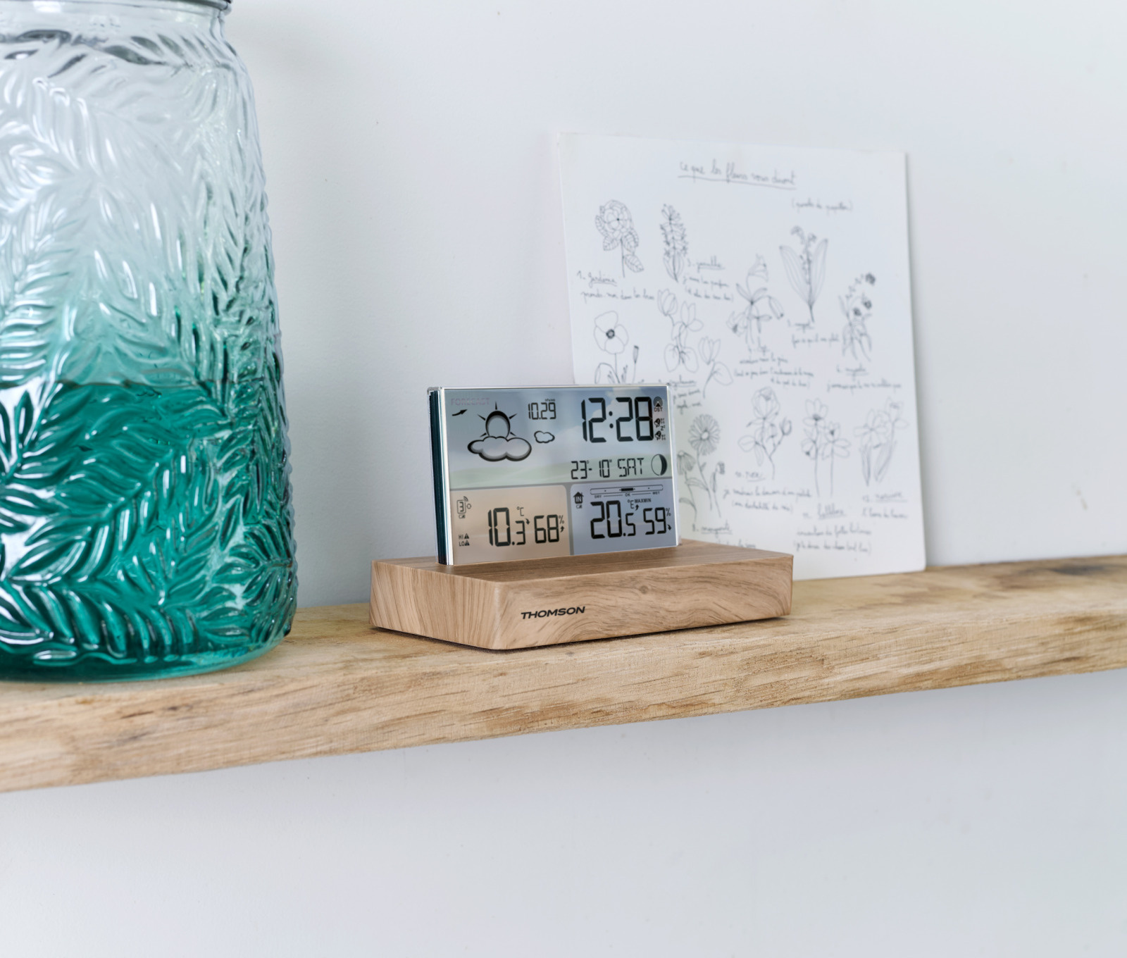 Digitale Wetterstation auf einem Holzregal. Zeigt Zeit, Datum, Wetter und Temperatur an.