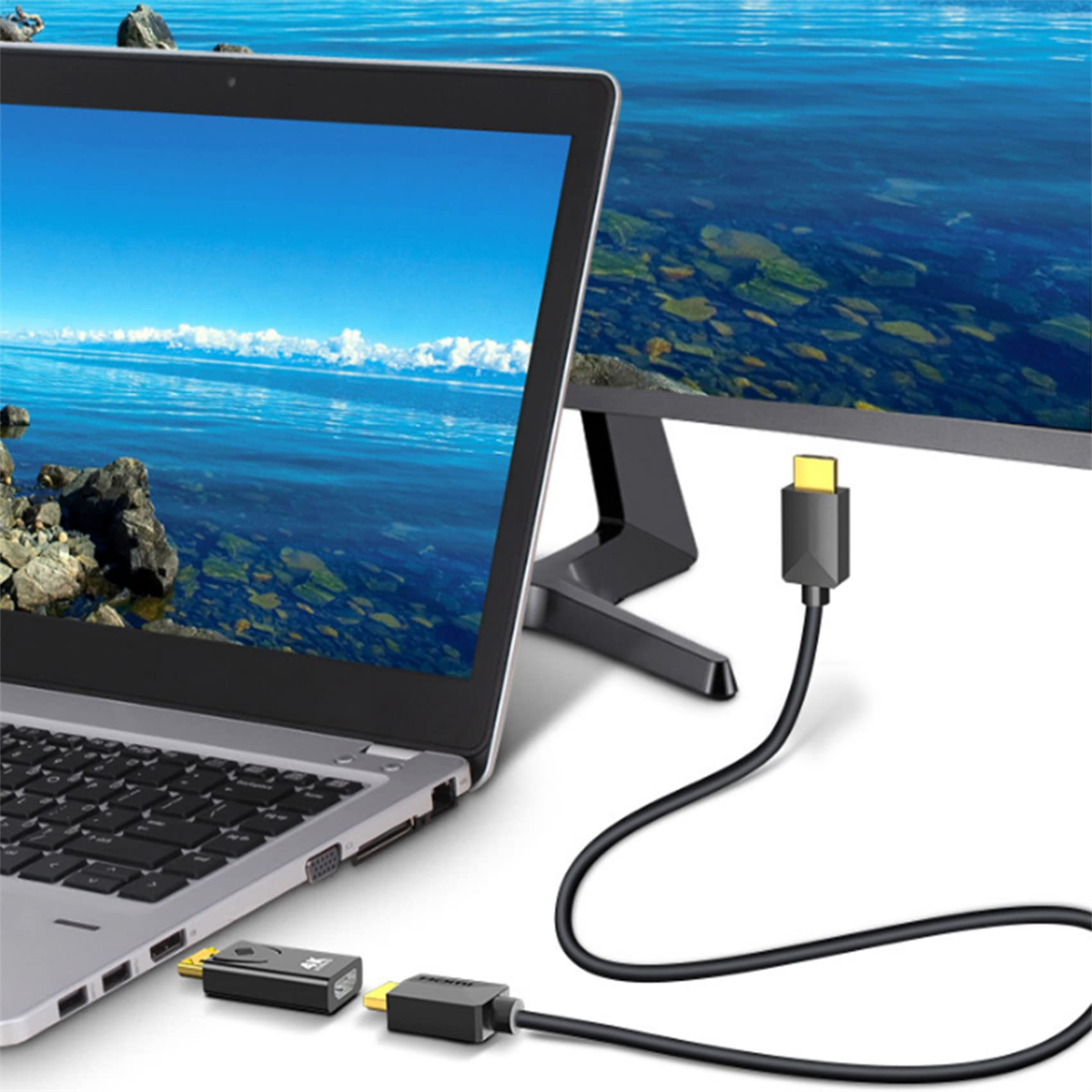 Laptop und Monitor mit verbundenen Kabeln. Der Bildschirm zeigt eine malerische Wassersicht.
