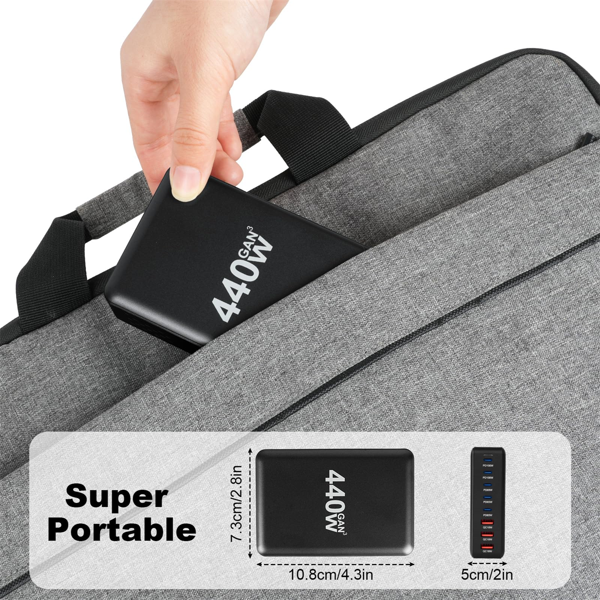 Eine Hand hält einen schwarzen Netzadapter mit dem Text „440W“. Eine Laptoptasche im Hintergrund.