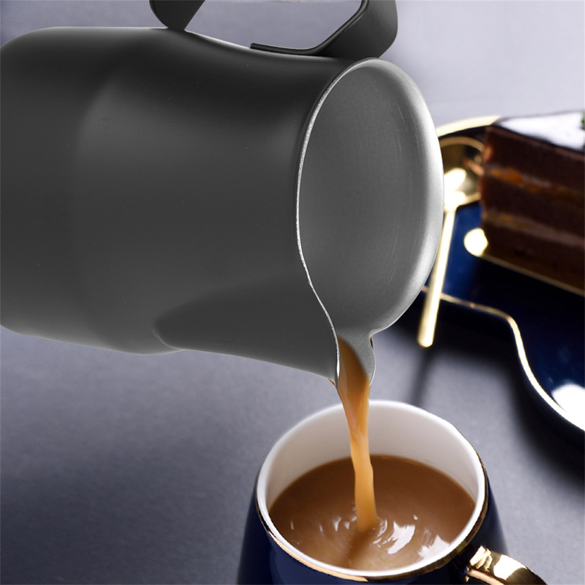 Schwarzer Krug gießt Flüssigkeit in eine blau-goldene Tasse.