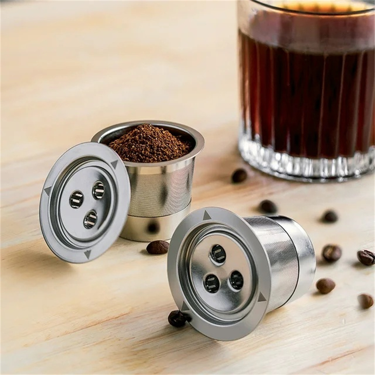 Kaffeefilterhalter mit Kaffeesatz, Kaffeebohnen und einem Glas Kaffee.