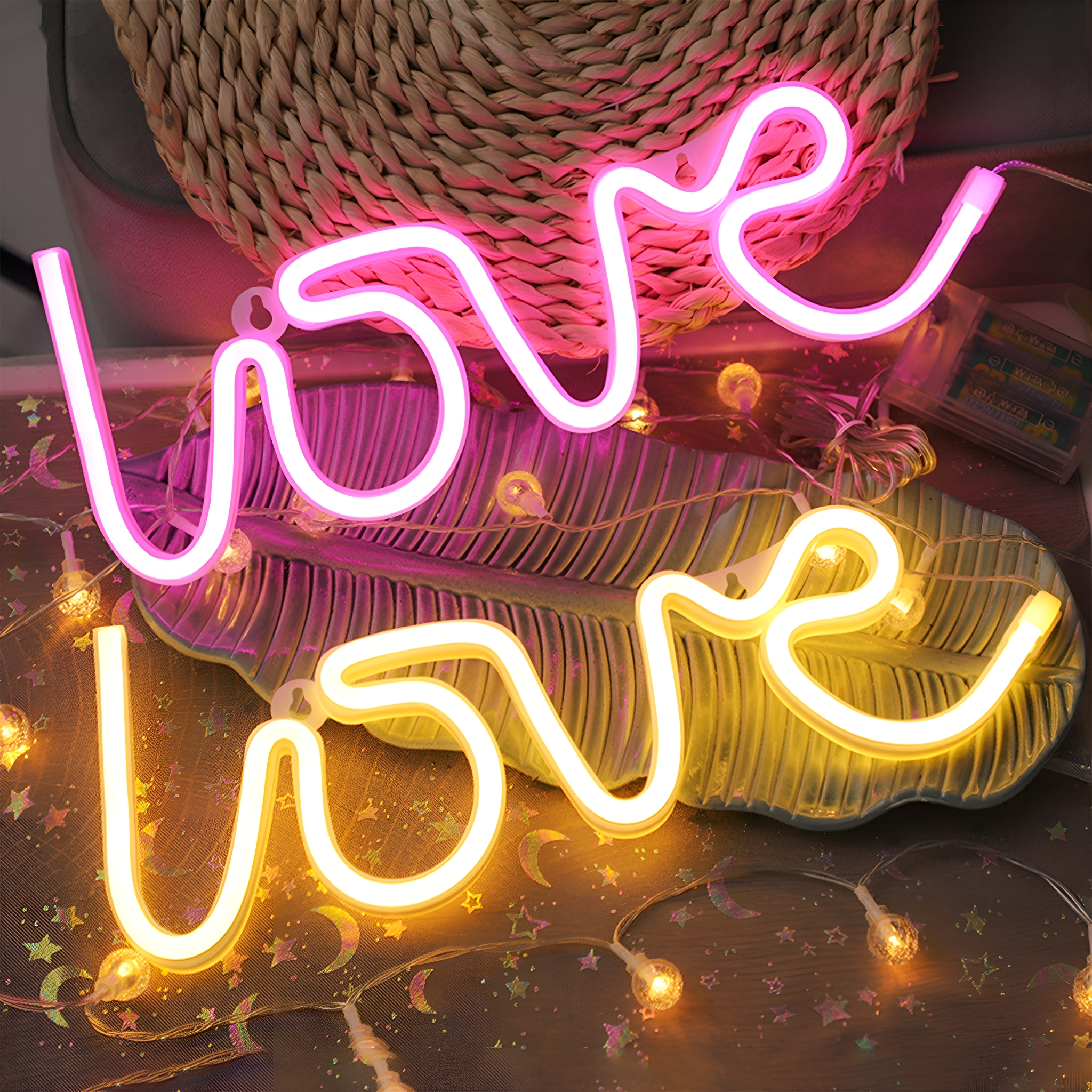 Das Wort 'Liebe' steht in Neonlichtern. Zwei sind rosa und eins ist gelb.