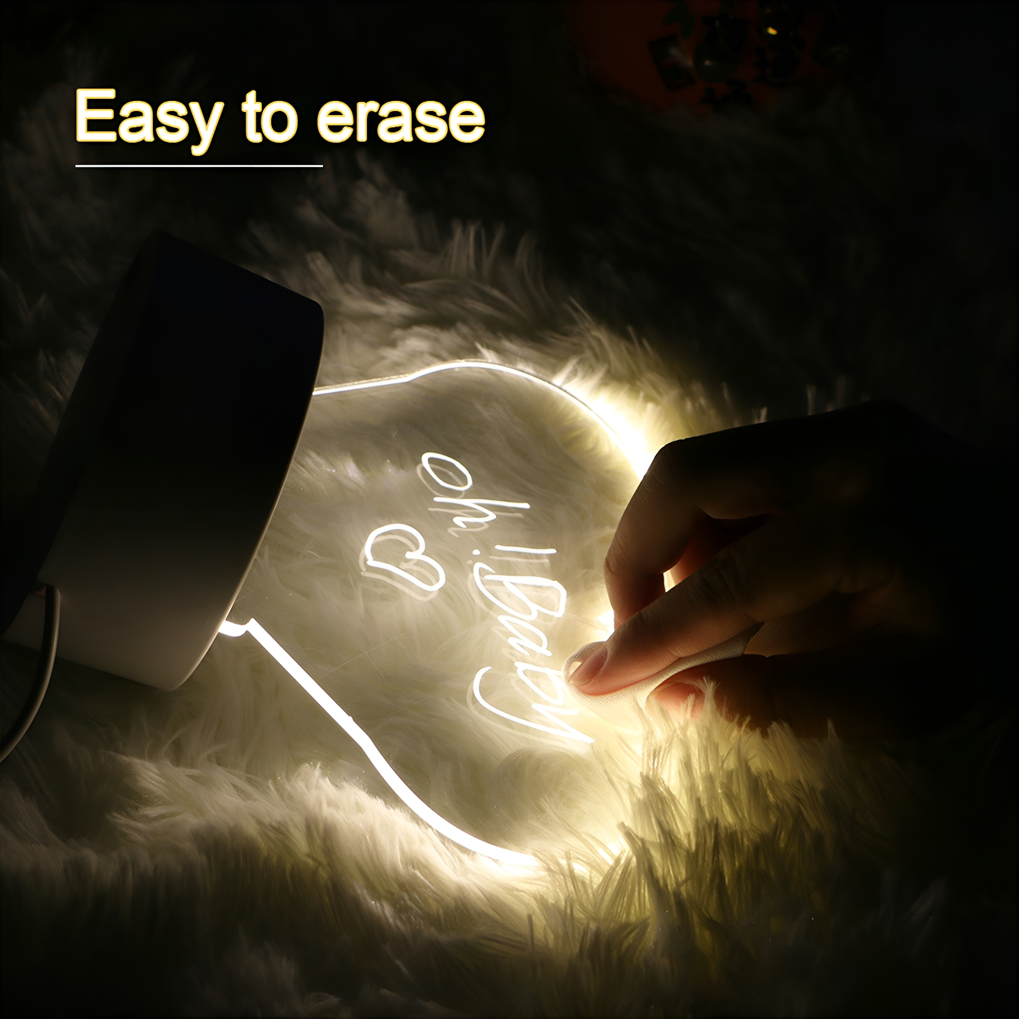 Eine Hand berührt ein beleuchtetes herzförmiges Licht mit dem Text "Oh Baby" darauf.