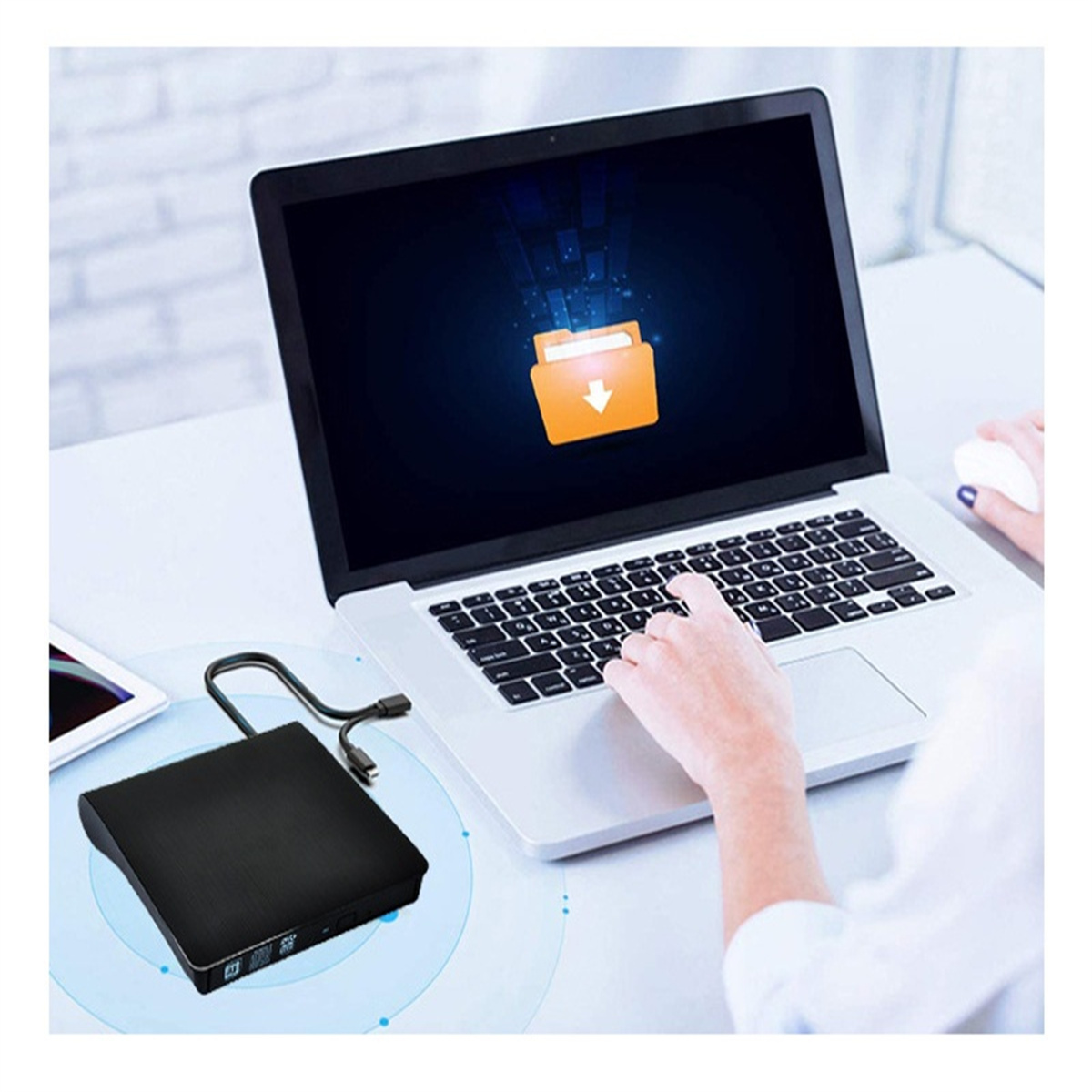 Frau benutzt Laptop, mit USB-Laufwerk und weißer Maus auf dem Tisch.