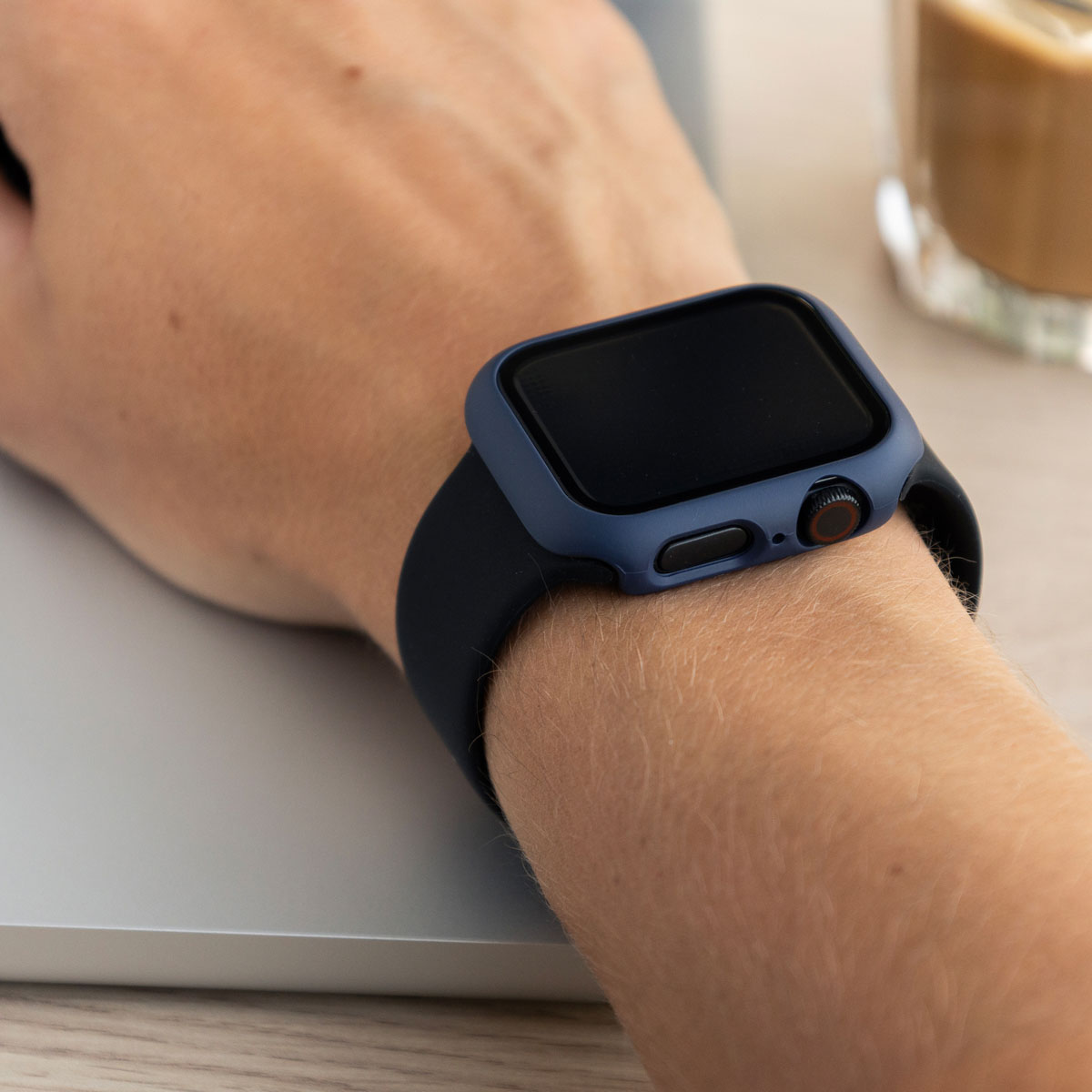 A person's wrist with a navy blue smartwatch. The person is using the watch.