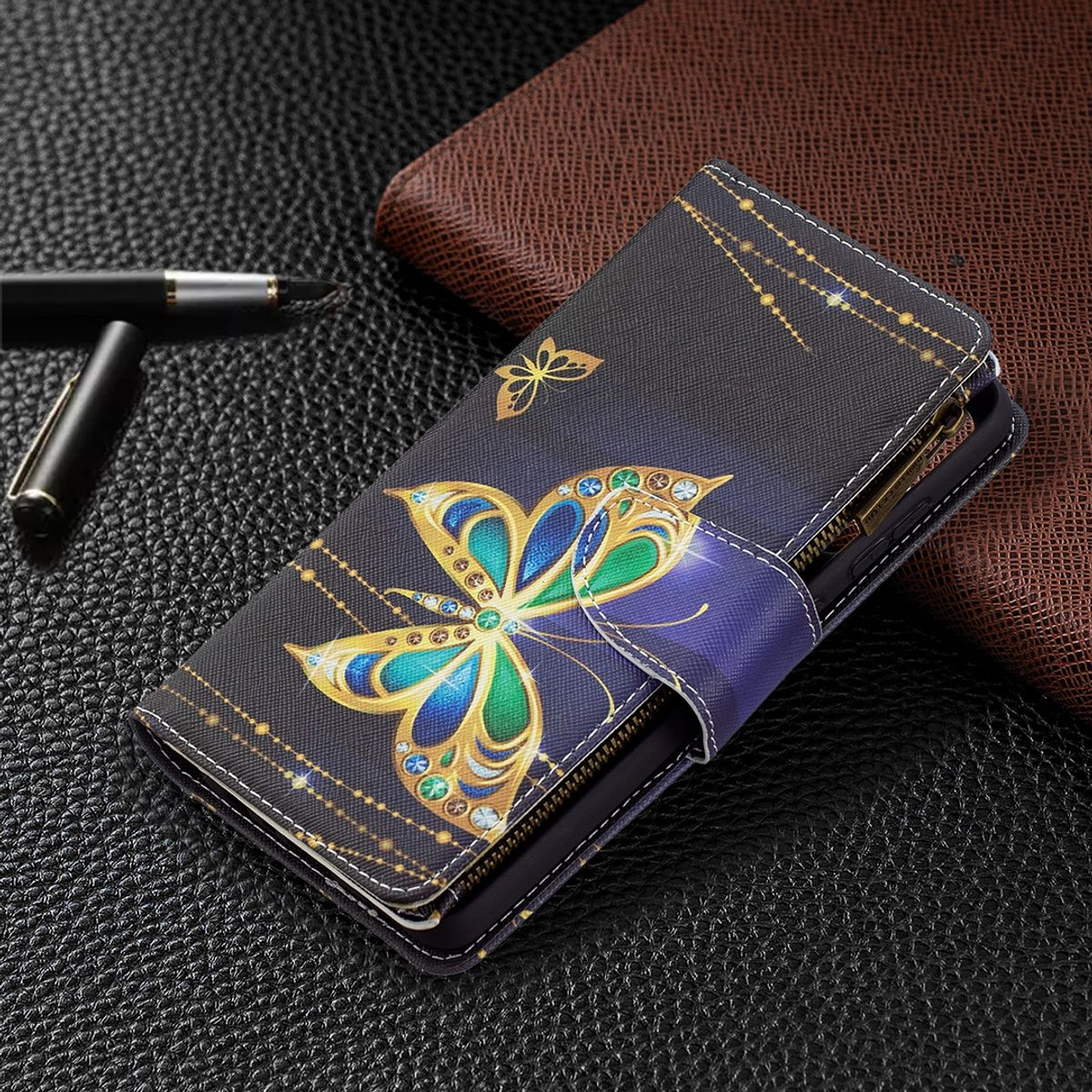 Nahaufnahme einer Handyhülle mit Schmetterlingsmotiv. Sie zeigt ein Schmetterlingsdesign mit Gold- und Juwelenakzenten.