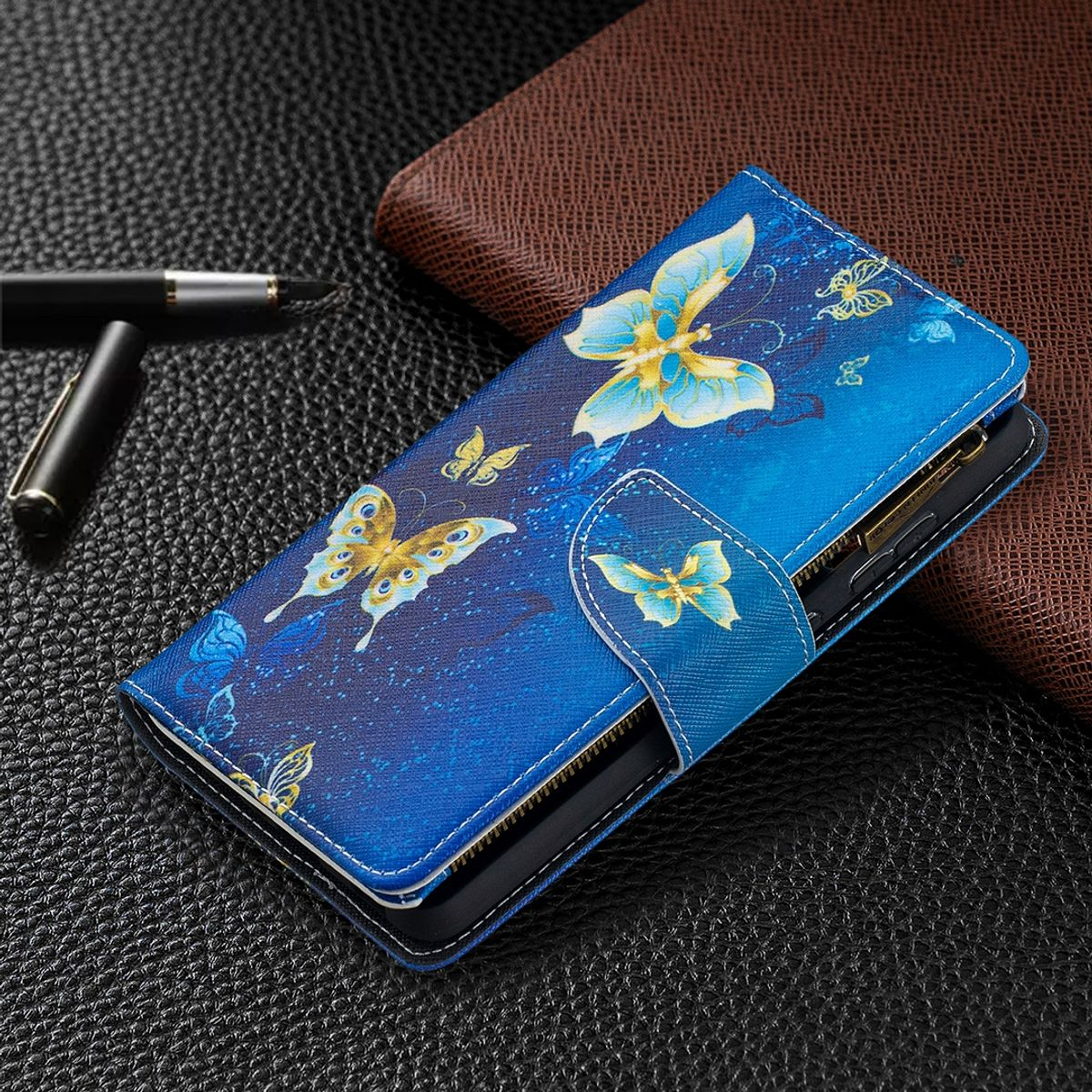 Blaue Handyhülle mit Schmetterlingsdesign, geöffnet auf dunkler Oberfläche.