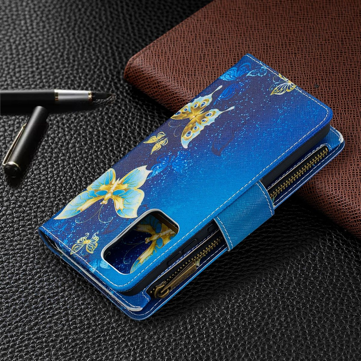 Eine blaue Handyhülle mit Schmetterlingsdesign, mit Reißverschluss geöffnet, auf dunkler Oberfläche.