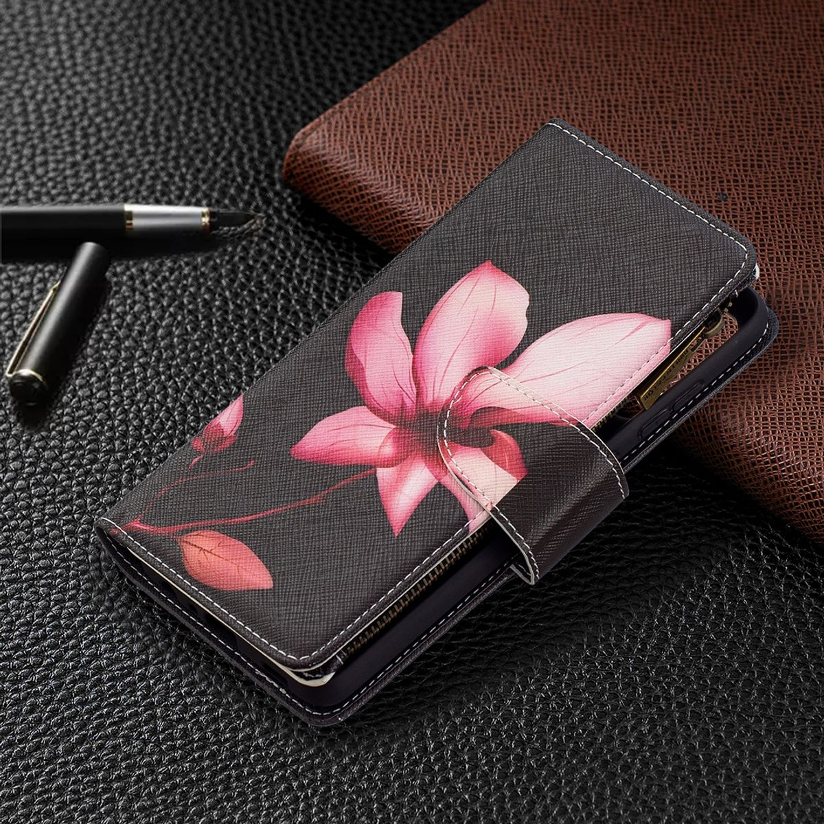 Eine Handy-Geldbörsenhülle mit floralem Design geöffnet. Die Hülle liegt auf Leder.