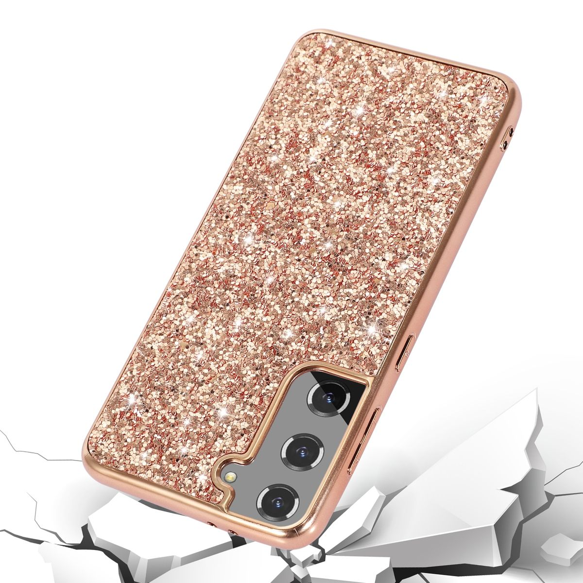 Roségoldfarbene Handyhülle auf rissiger, weißer Oberfläche. Das Telefon hat drei Kameras.