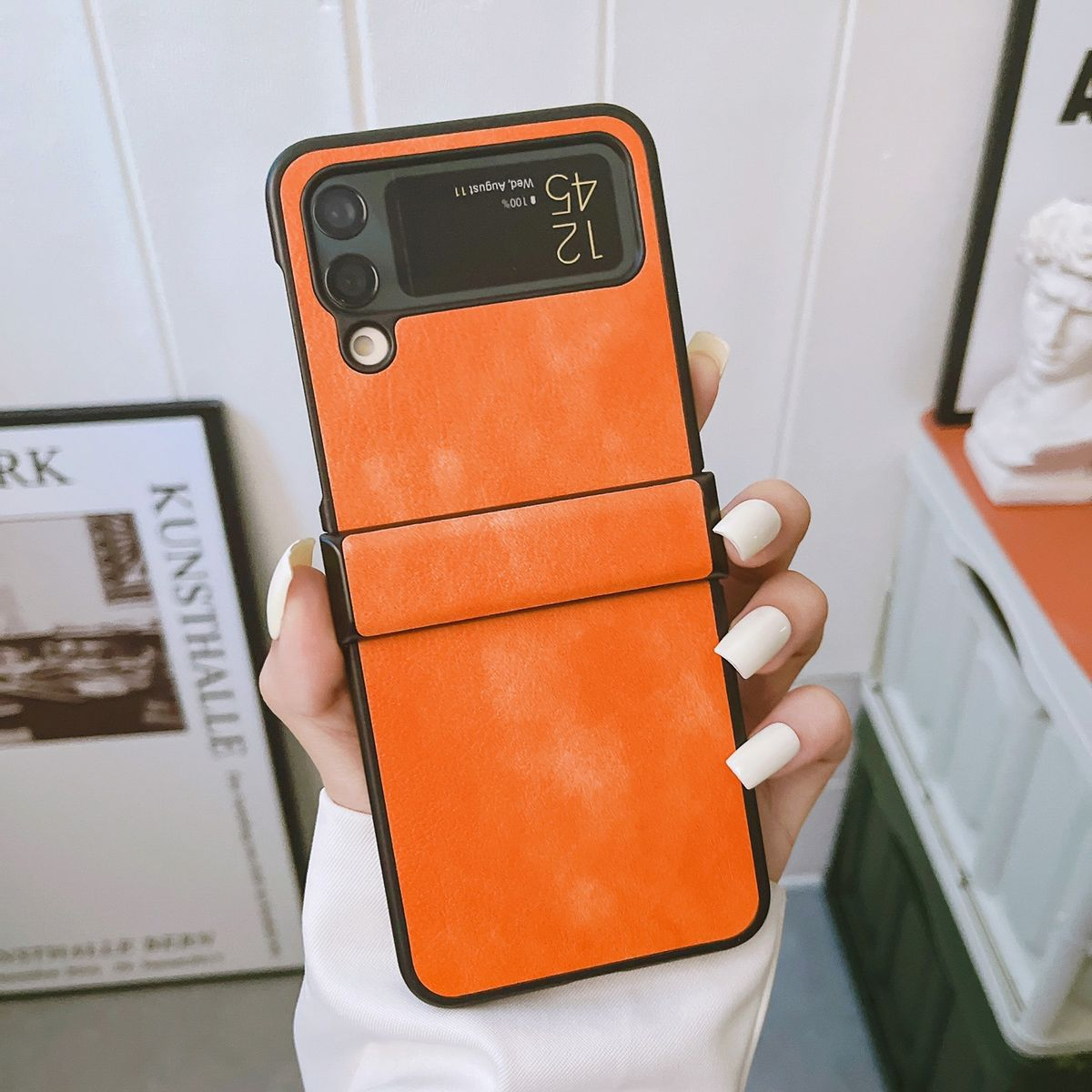 Orangefarbene Handyhülle, Samsung Galaxy Z Flip 3, mit gefaltetem Bildschirm.