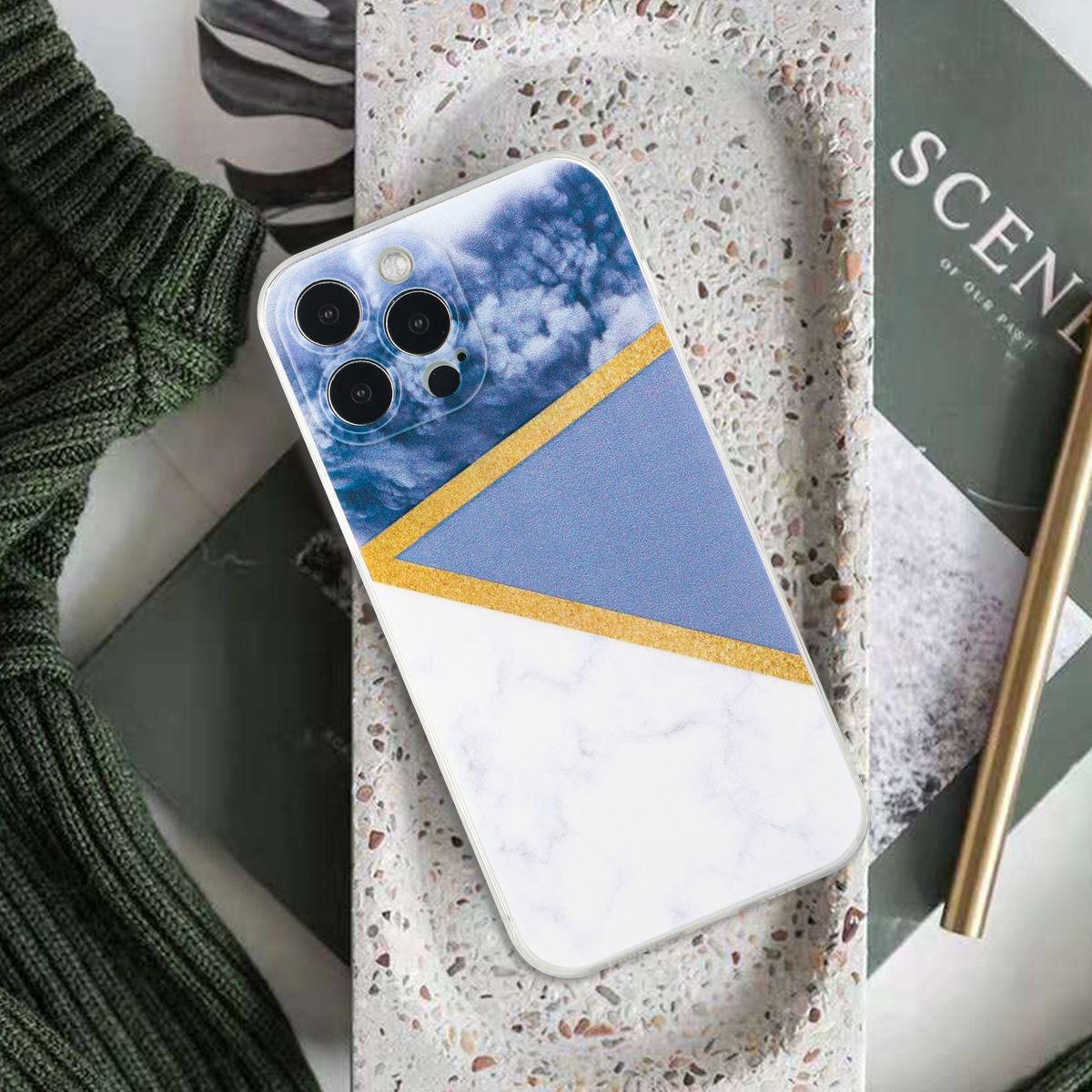 Handyhülle mit weißem, blauem und goldenem geometrischen Design. Das Telefon liegt auf einem Tablett.