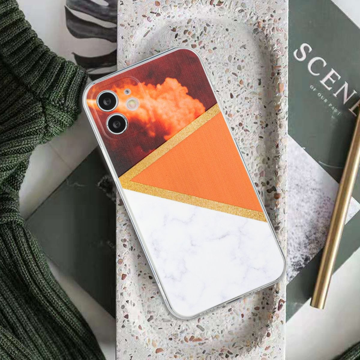 Eine Handyhülle mit Farbblock-Design: orange, weiß und goldfarbene Akzente.