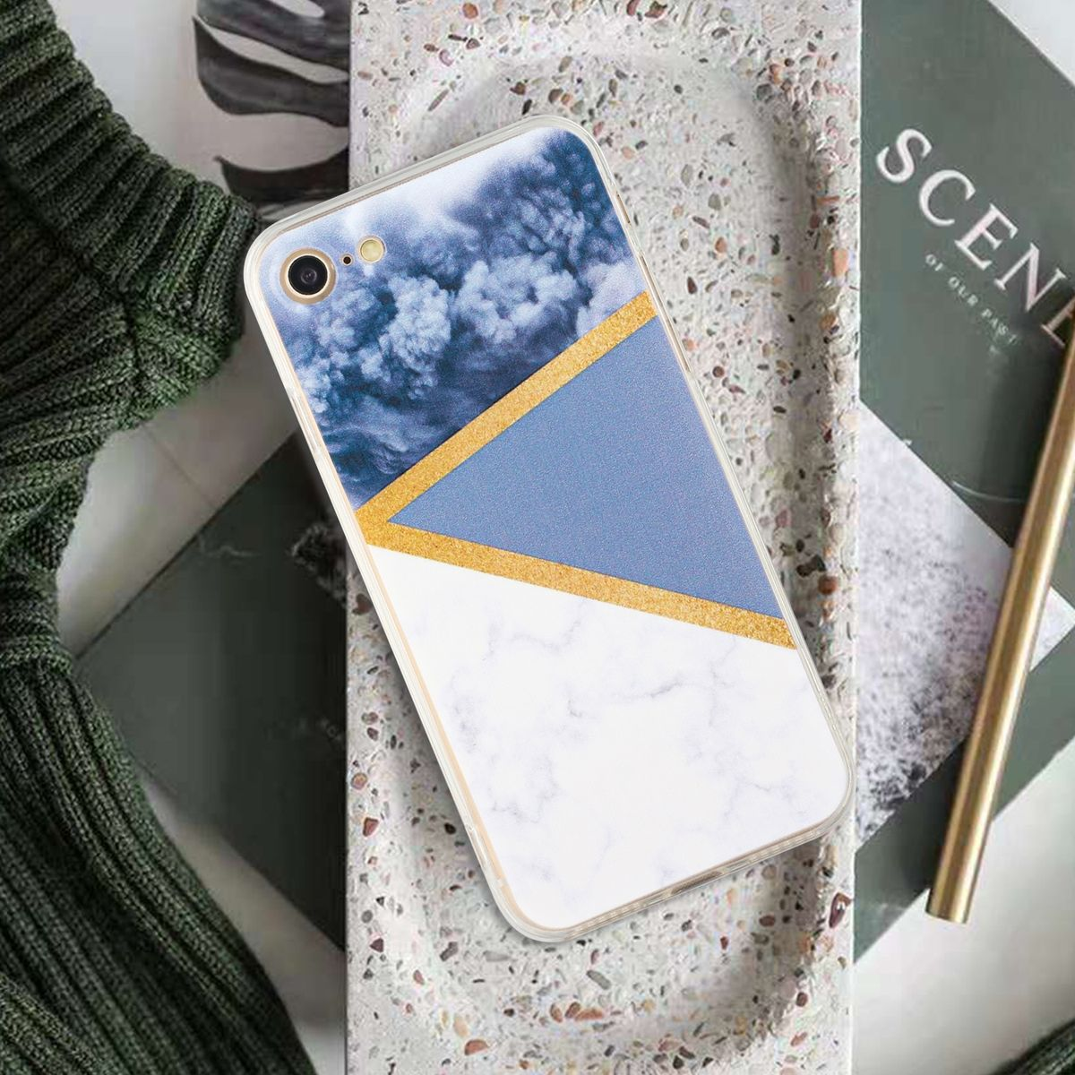 Handyhülle mit blauem und weißem Marmordesign und goldenen Akzenten. Ein Telefon ist darin. Auf einem Tablett platziert.