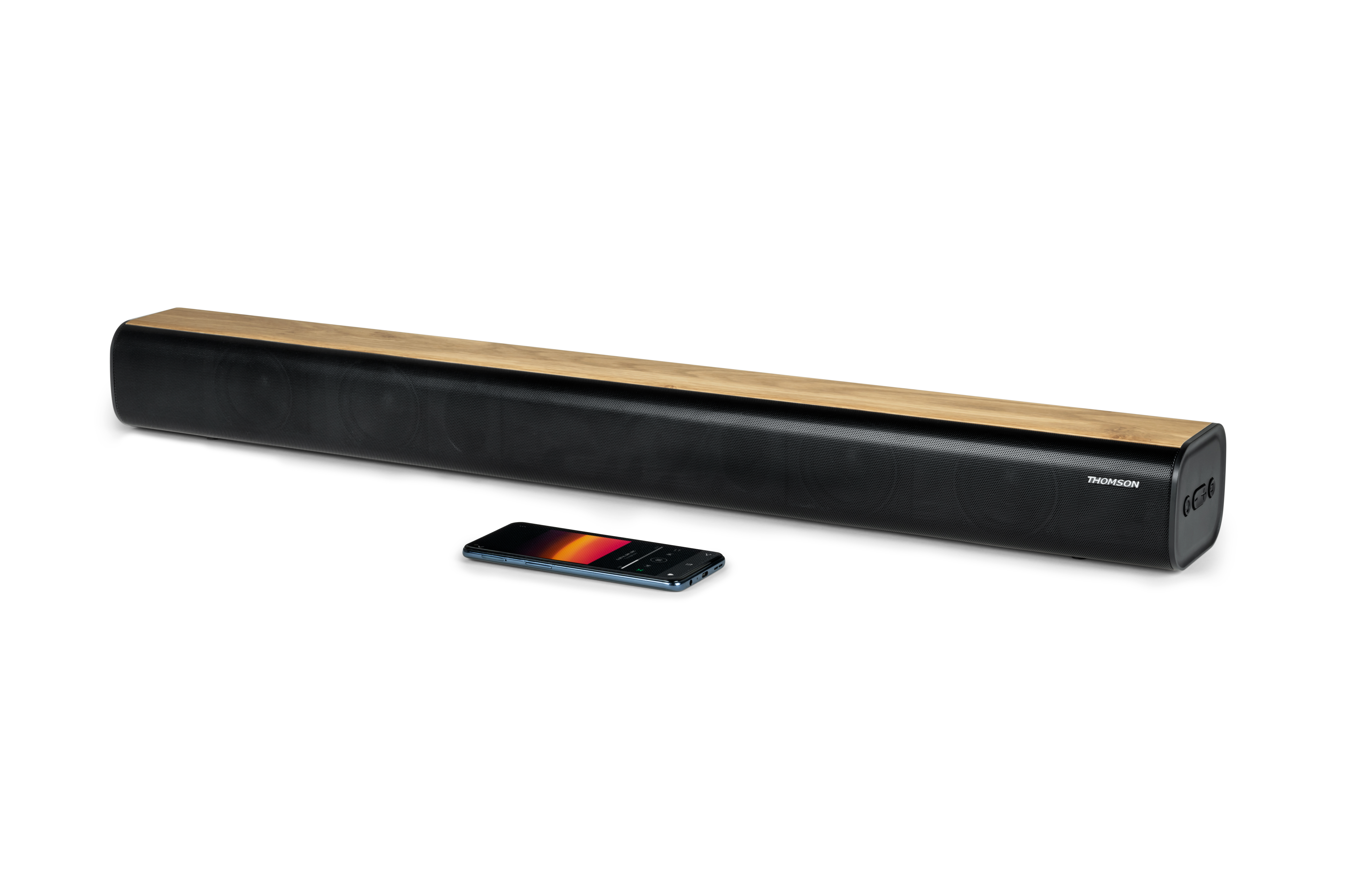 Czarny soundbar z drewnianym blatem, obok smartfon z aplikacją muzyczną.