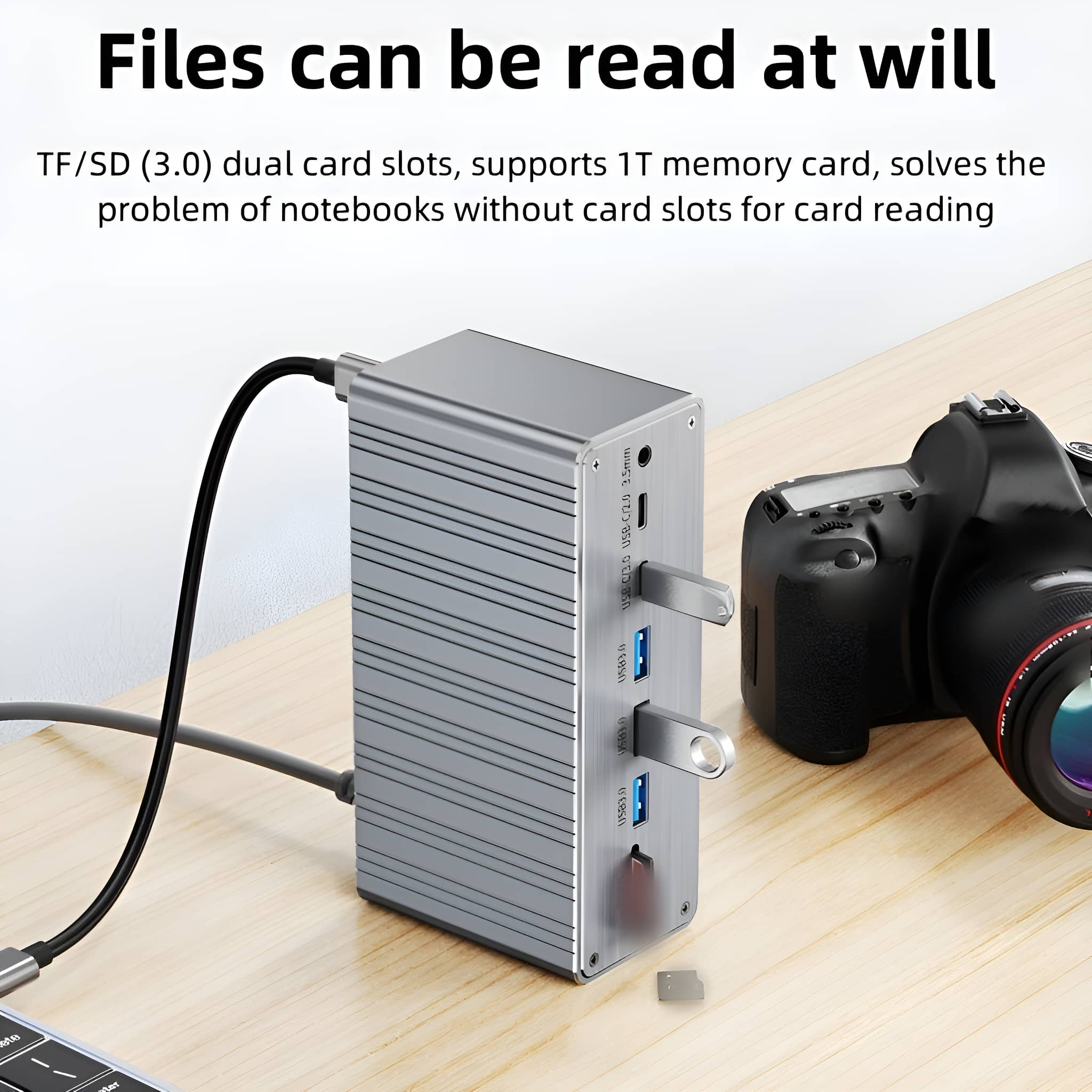 Silberner USB-Hub mit Anschlüssen und zwei angeschlossenen USB-Laufwerken. Eine Kamera im Hintergrund.