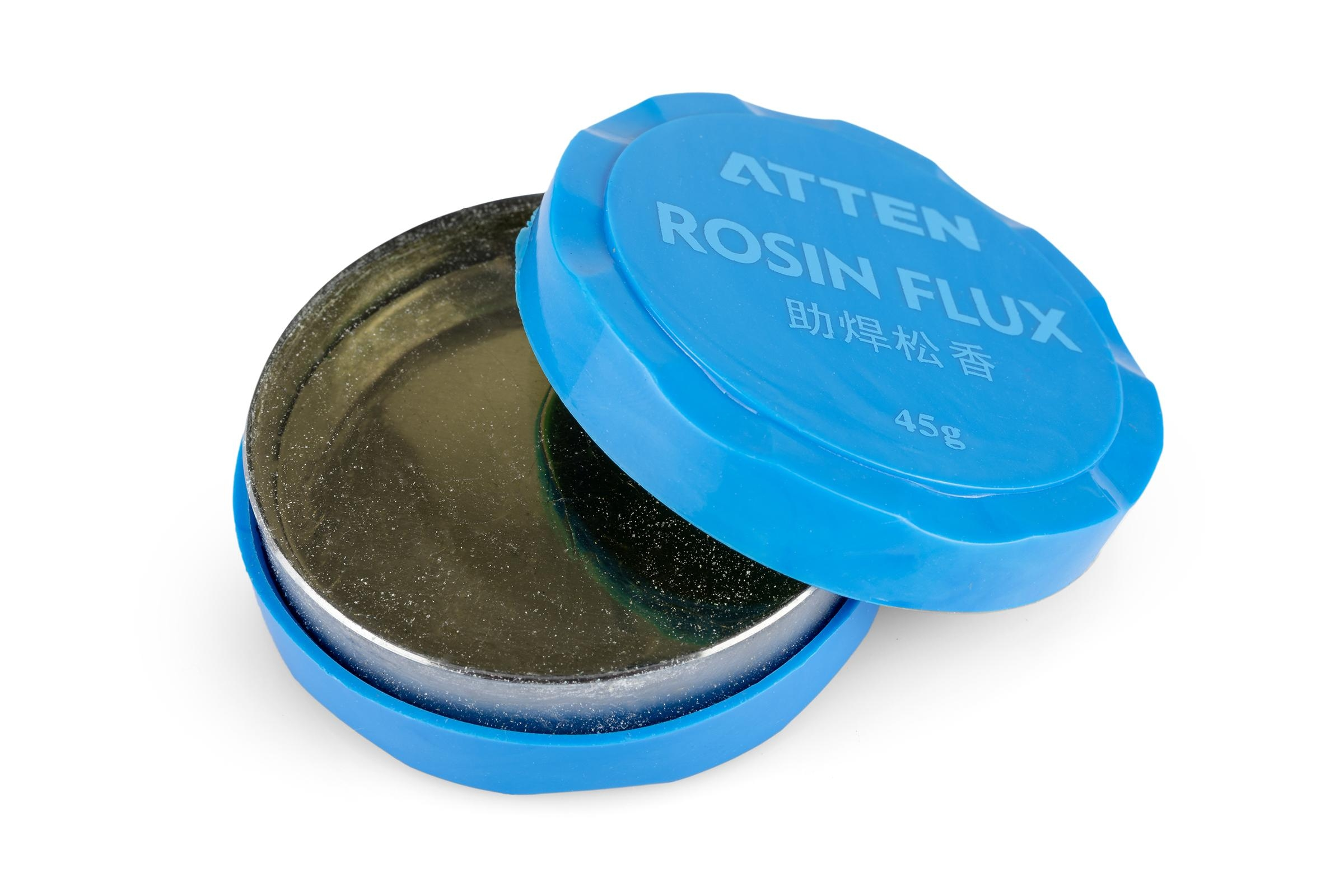 Offener blauer Kolophonium-Flussmittelbehälter. Der Deckel ist abgenommen und gibt eine silberne Substanz frei.