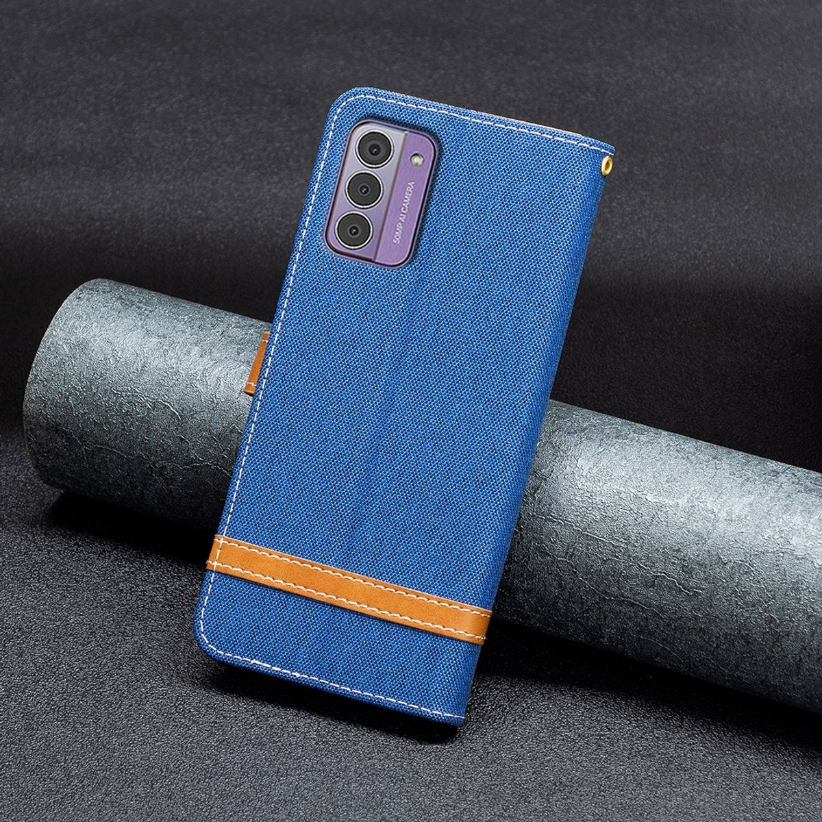 Eine blaue Handyhülle mit braunem Riemen und einem Telefon darin. Die Hülle liegt auf dunklem Untergrund.