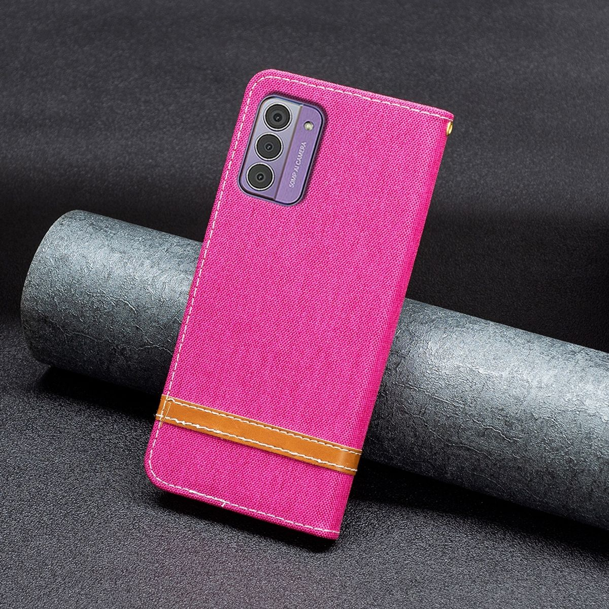Pinkfarbene Handyhülle mit braunem Riemen. Telefonkameras sind sichtbar. Der Hintergrund ist eine dunkle Oberfläche.