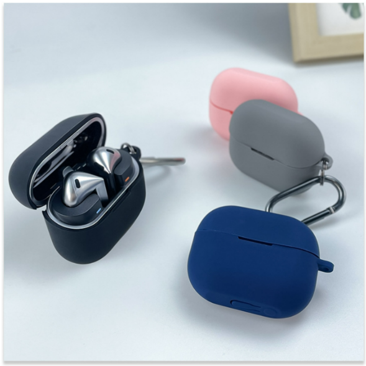 Auricolari all'interno di una custodia nera, con altre due custodie colorate nelle vicinanze.