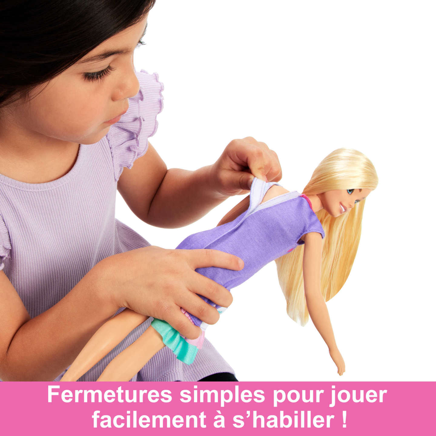 Mädchen zieht einer Barbie-Puppe das Kleid an. Sie zieht das Kleid der Puppe herunter. Ein rosa Banner unten.