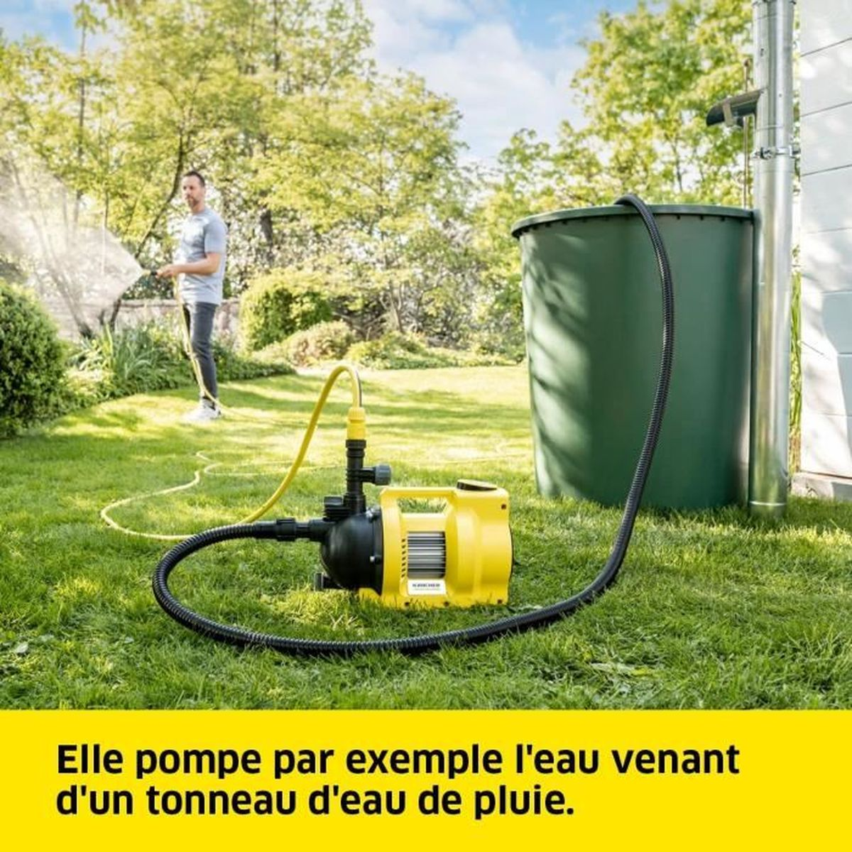 Ein Mann bewässert den Rasen neben einer gelben Pumpe. Ein grüner Tank und ein schwarzer Schlauch sind sichtbar.