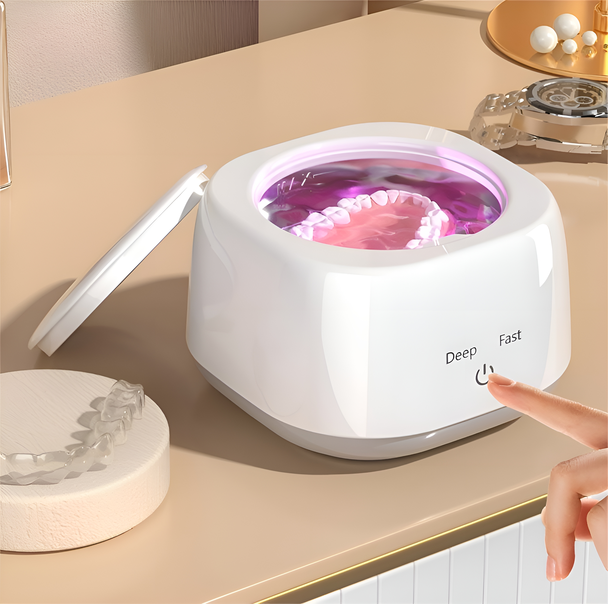 Eine weiße Zahnprothesenreinigungsmaschine mit Zahnprothesen im Inneren. Ein Finger drückt den Einschalter.