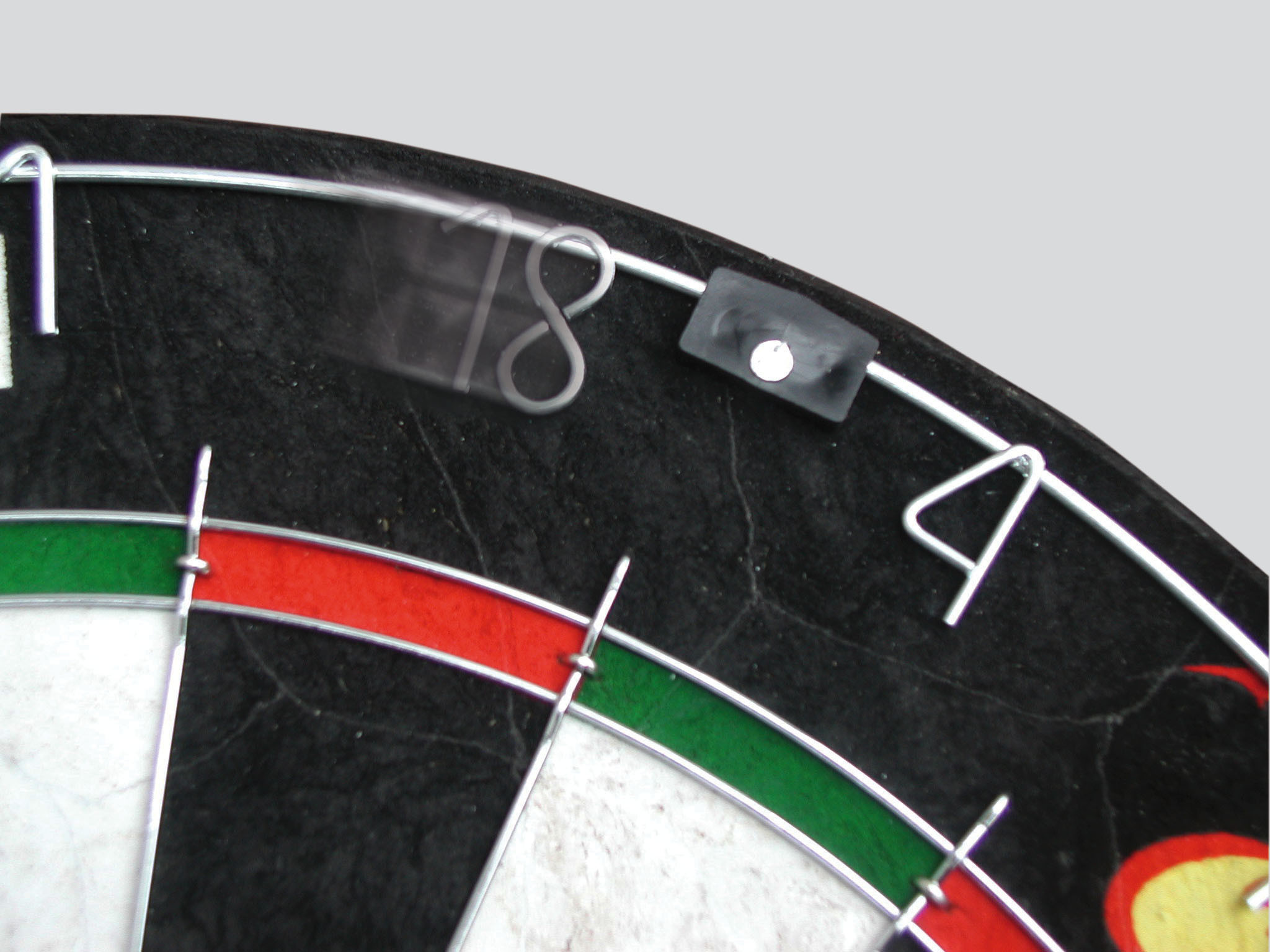 Dartbord sectie met nummer 18. Rode, groene en zwarte kleuren. Grijze achtergrond.