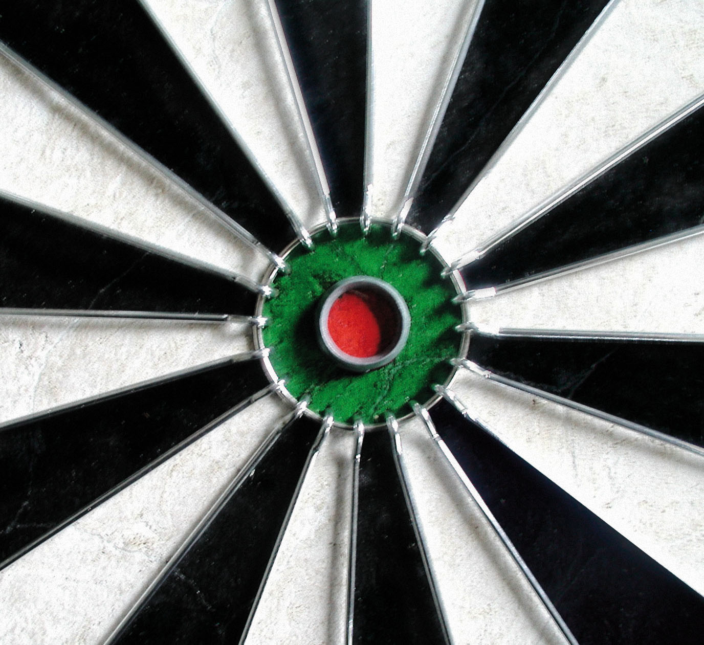 Dartbord met zwarte en witte radiale secties. Groen centrum met een rode bullseye. Zilveren draadframe.