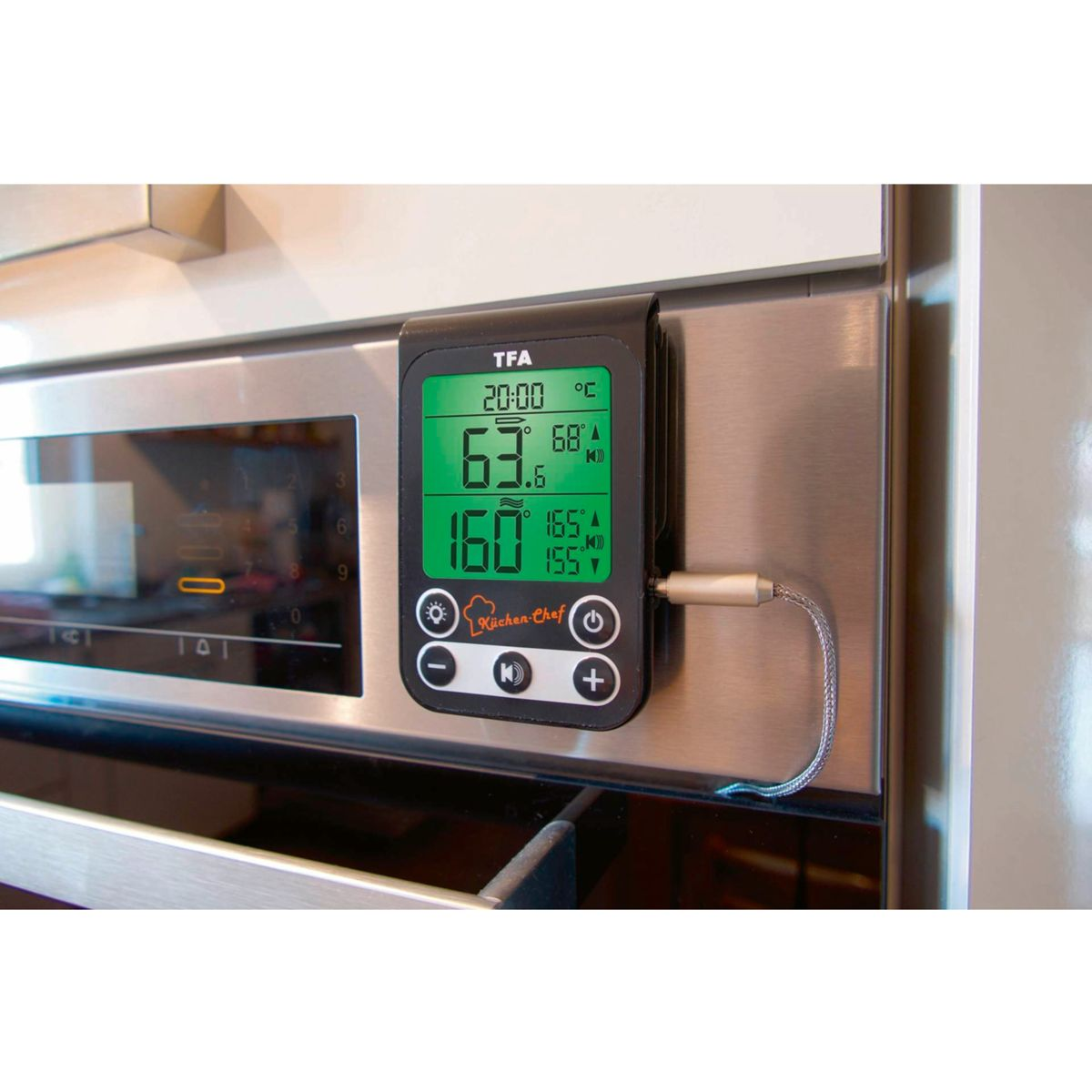 Ein digitales Thermometer ist an einem Edelstahlgerät befestigt. Der Bildschirm zeigt Temperaturmesswerte in Celsius und Fahrenheit.