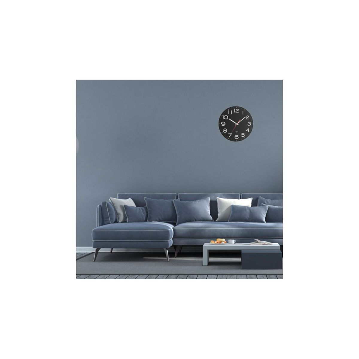 Niebieska ściana z niebieską kanapą i czarnym zegarem na ścianie. Sofa ma poduszki i dywan.