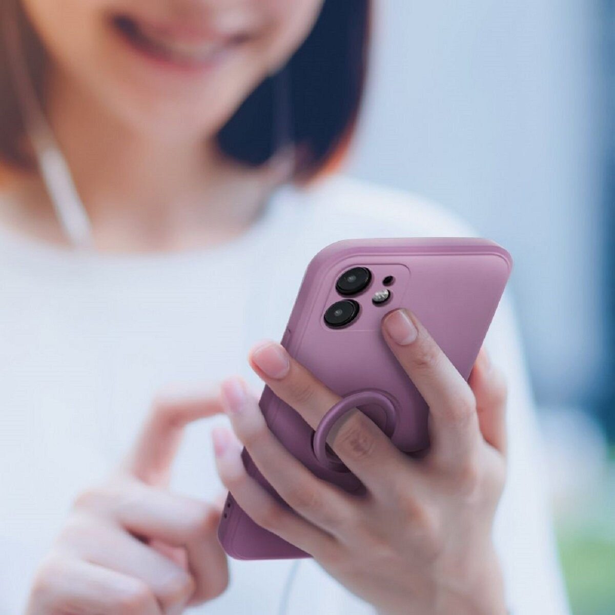 Telefon mit lila Hülle. Eine Frau hält das Telefon. Das Telefon hat einen Ring.