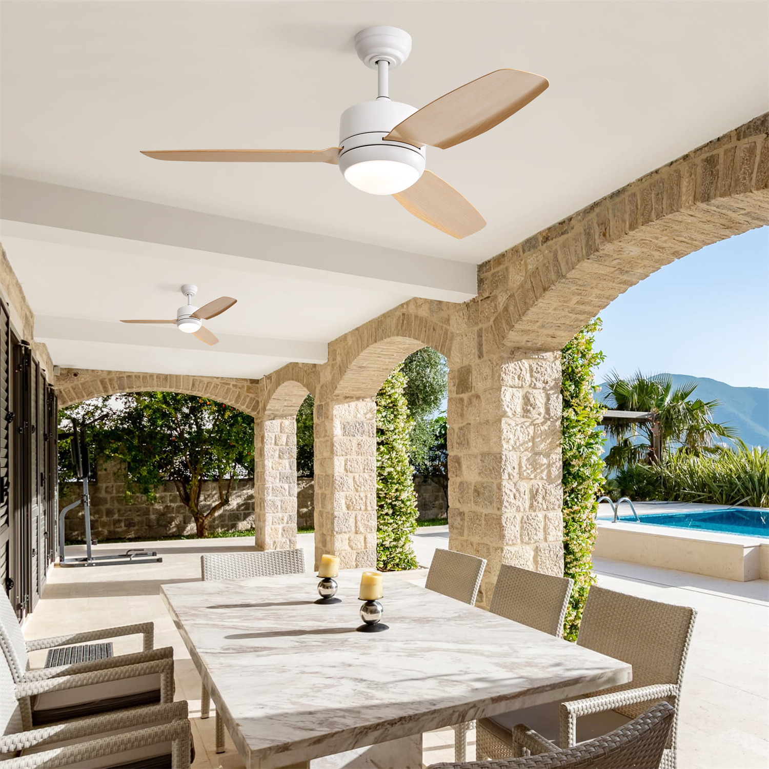 Eine Terrasse im Freien mit Deckenventilator, Esstisch und Stühlen. Ein Swimmingpool ist im Hintergrund.