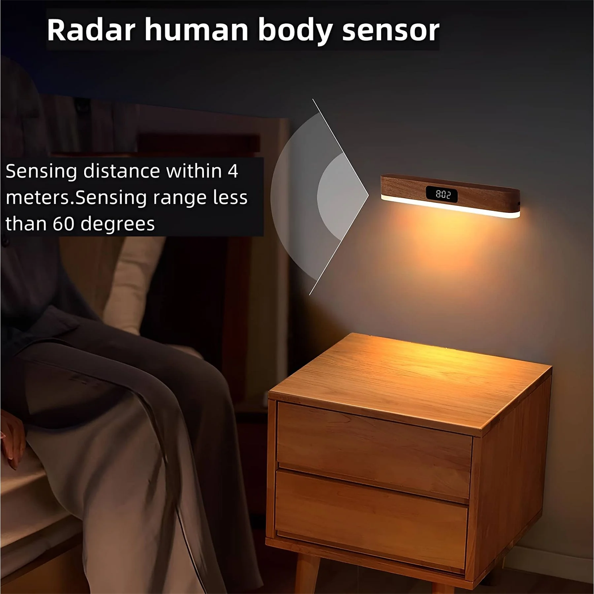 Ein Nachttisch aus Holz mit Licht und Sensor an der Wand. Eine Person sitzt im Hintergrund.