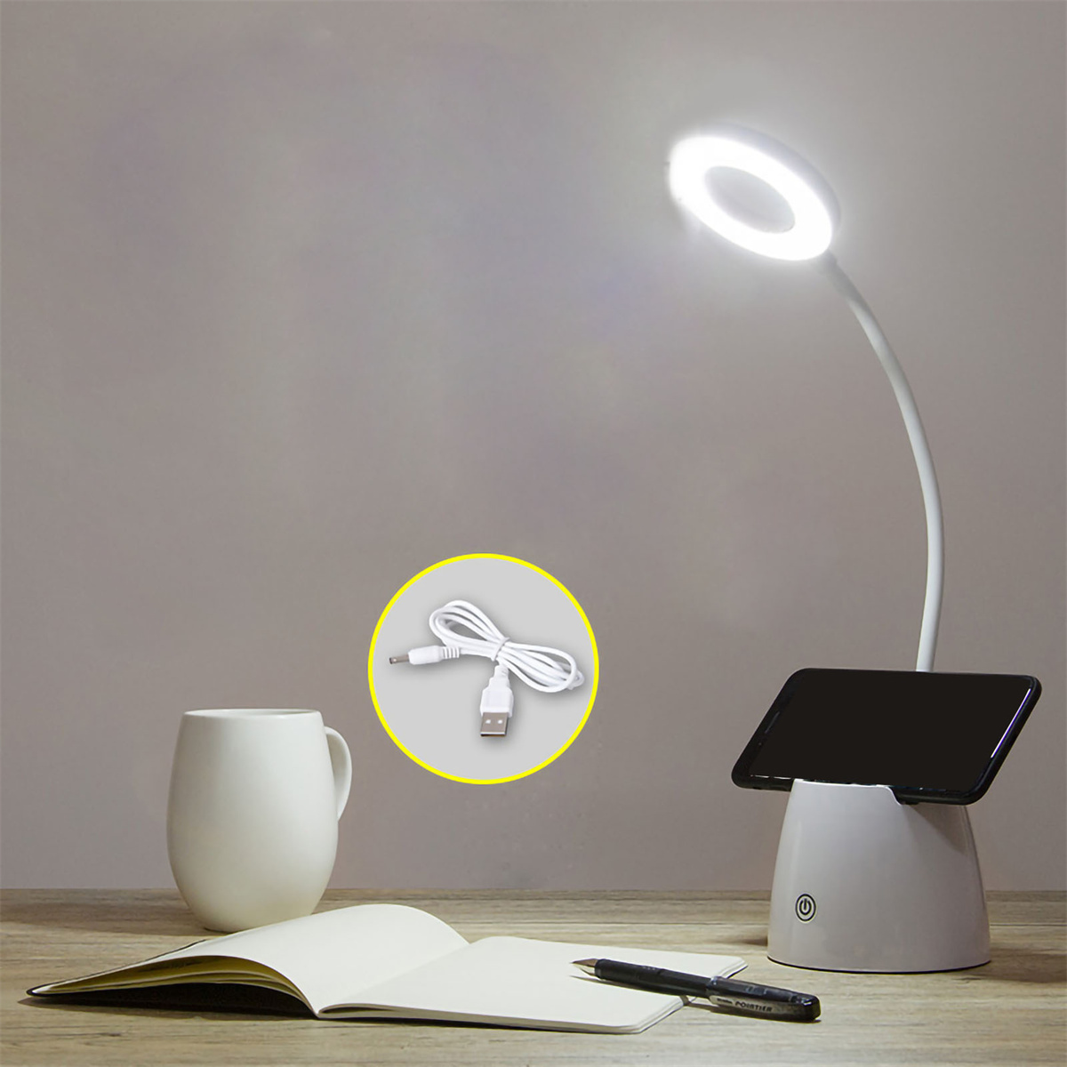 Schreibtischlampe mit weißem Sockel und Ringlicht. Ein Telefon liegt auf dem Sockel.