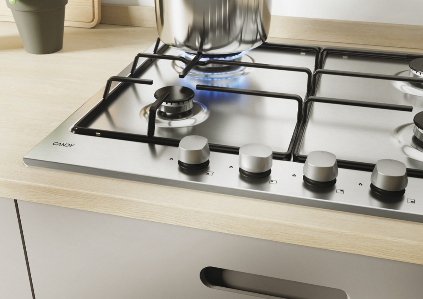 Zbliżenie na kuchenkę gazową z czterema palnikami, srebrnymi pokrętłami i drewnianym blatem.