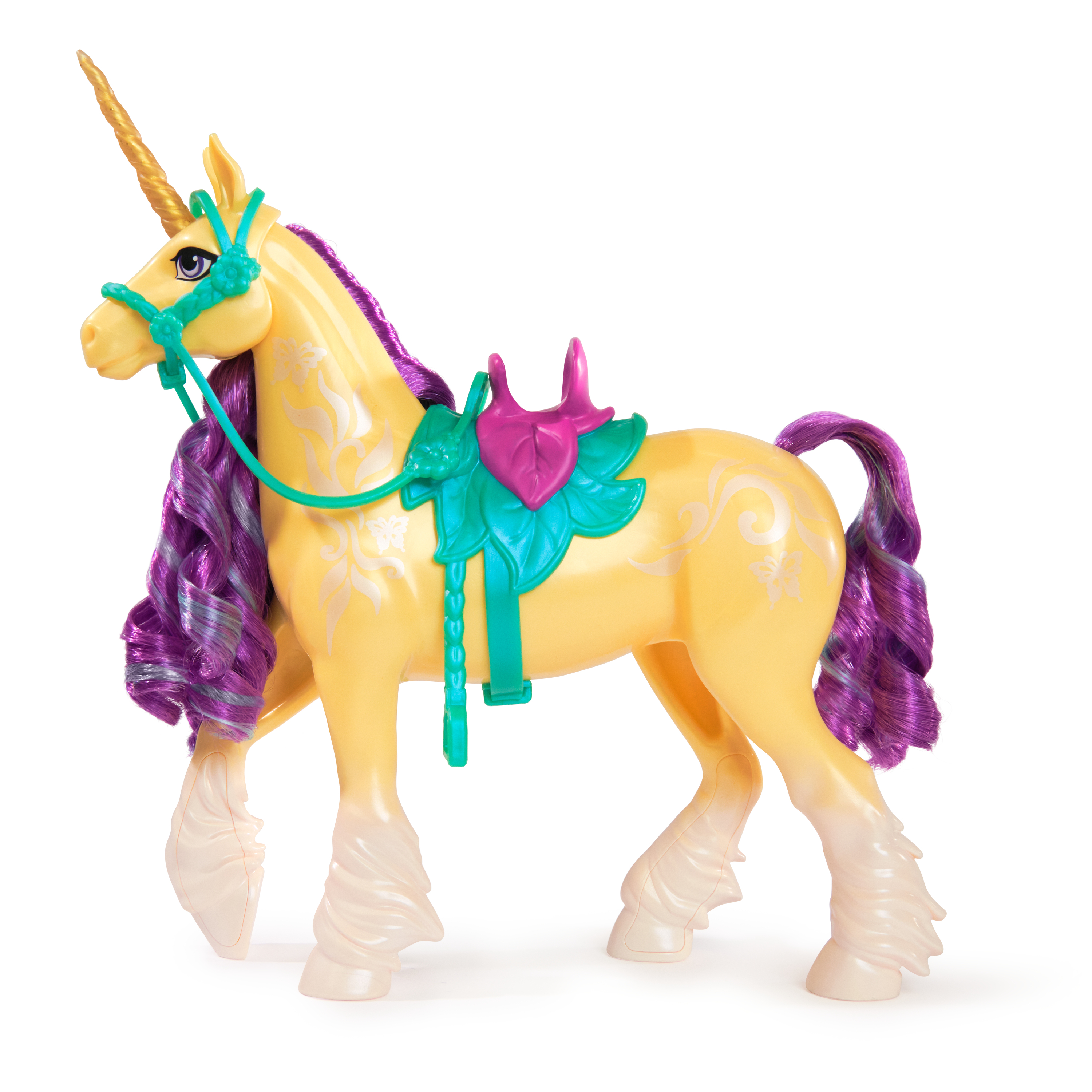 Unicorno giocattolo giallo con capelli rosa, sella verde e criniera viola. Sfondo bianco.