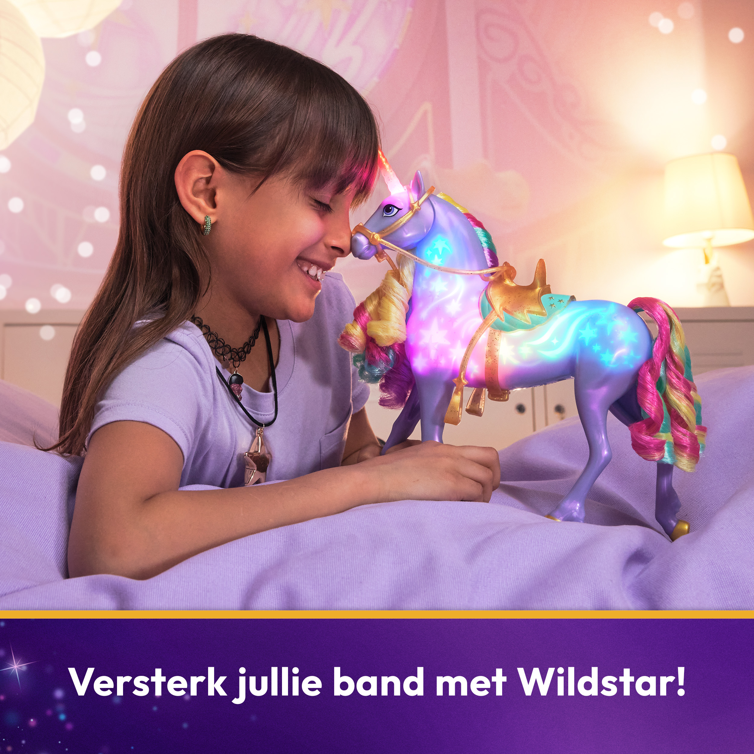 Una ragazza sorride mentre tocca un giocattolo unicorno luminoso. L'unicorno è blu, viola e giallo.