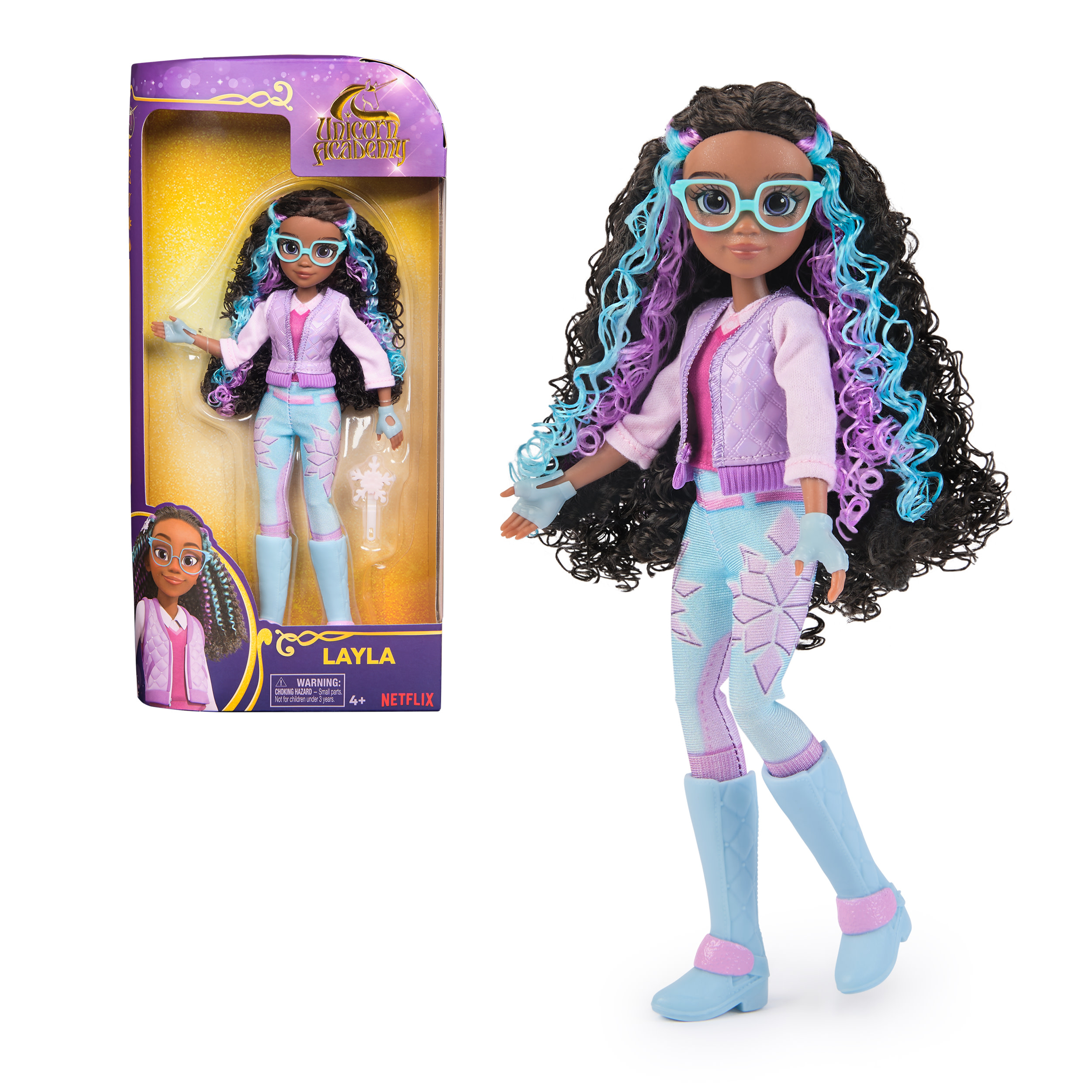 Muñeca Layla, con gafas, pelo azul y morado, y traje azul claro. Caja con imagen de la muñeca.