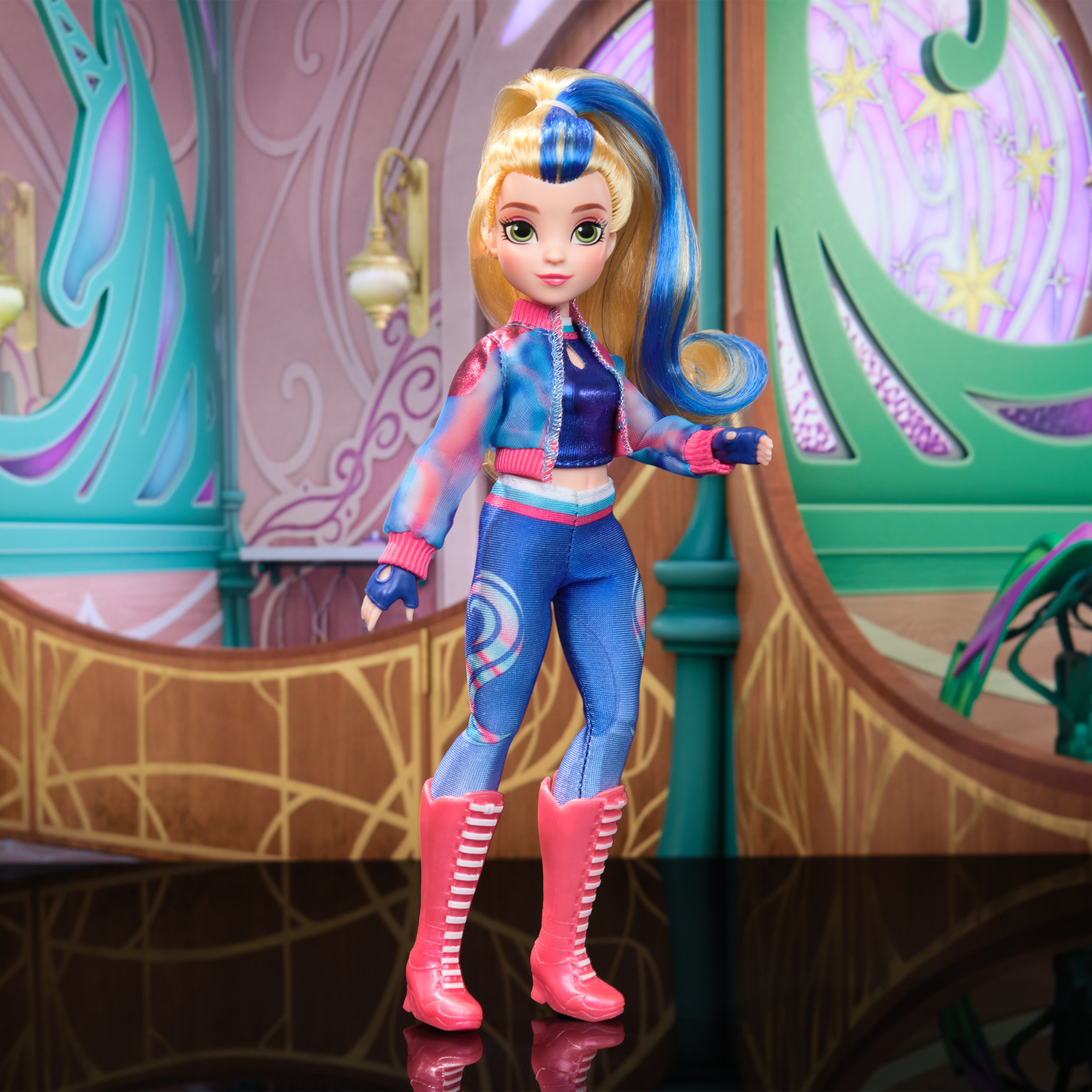 Lalka z niebieskimi i blond włosami, w kolorowym stroju i różowych butach, w pokoju.