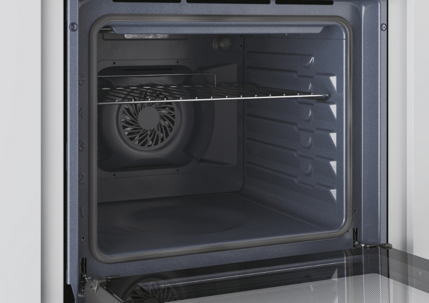Primo piano dell'interno vuoto del forno. Pareti grigio scuro, una griglia e una ventola visibili.