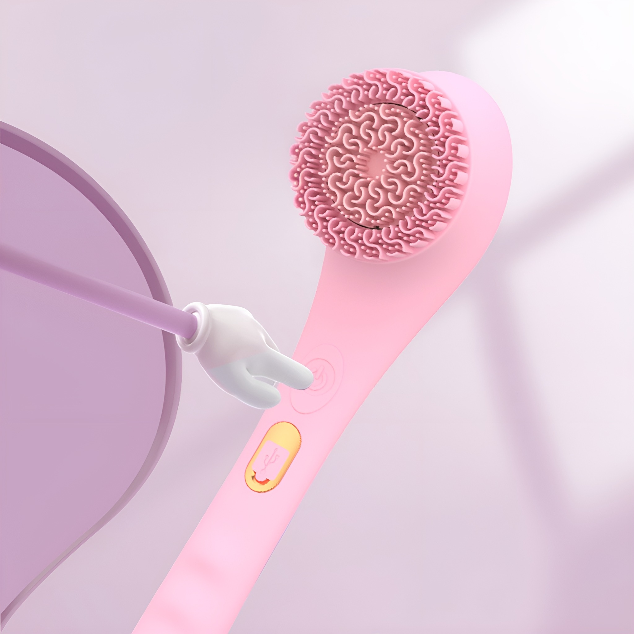 Eine rosa Gesichtsbürste mit einer Cartoon-Hand. Die Bürste hat einen strukturierten Kopf und einen Knopf.