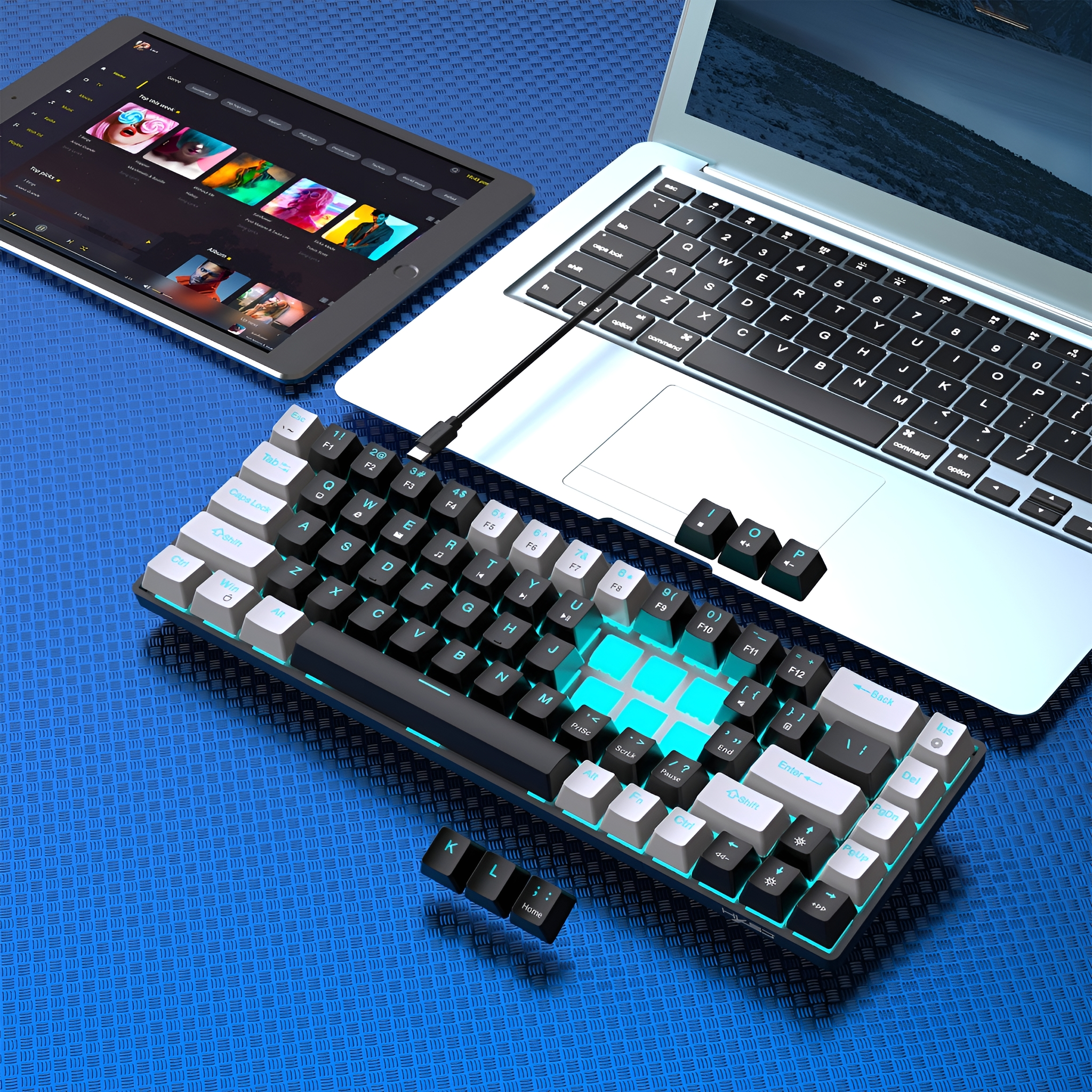 Eine schwarze Tastatur mit weißen und türkisfarbenen Tasten liegt auf einer blauen strukturierten Oberfläche, mit einem Laptop und einem Tablet.