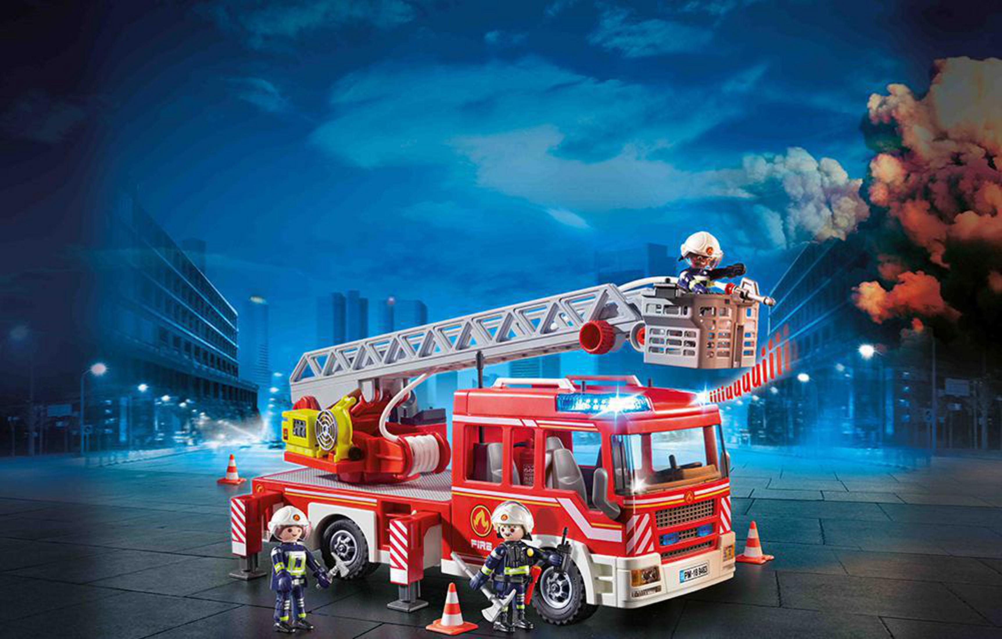 Ein rotes Feuerwehrspielzeug mit ausfahrbarer Leiter, drei Spielzeugfeuerwehrleuten und einer Stadtkulisse bei Nacht.