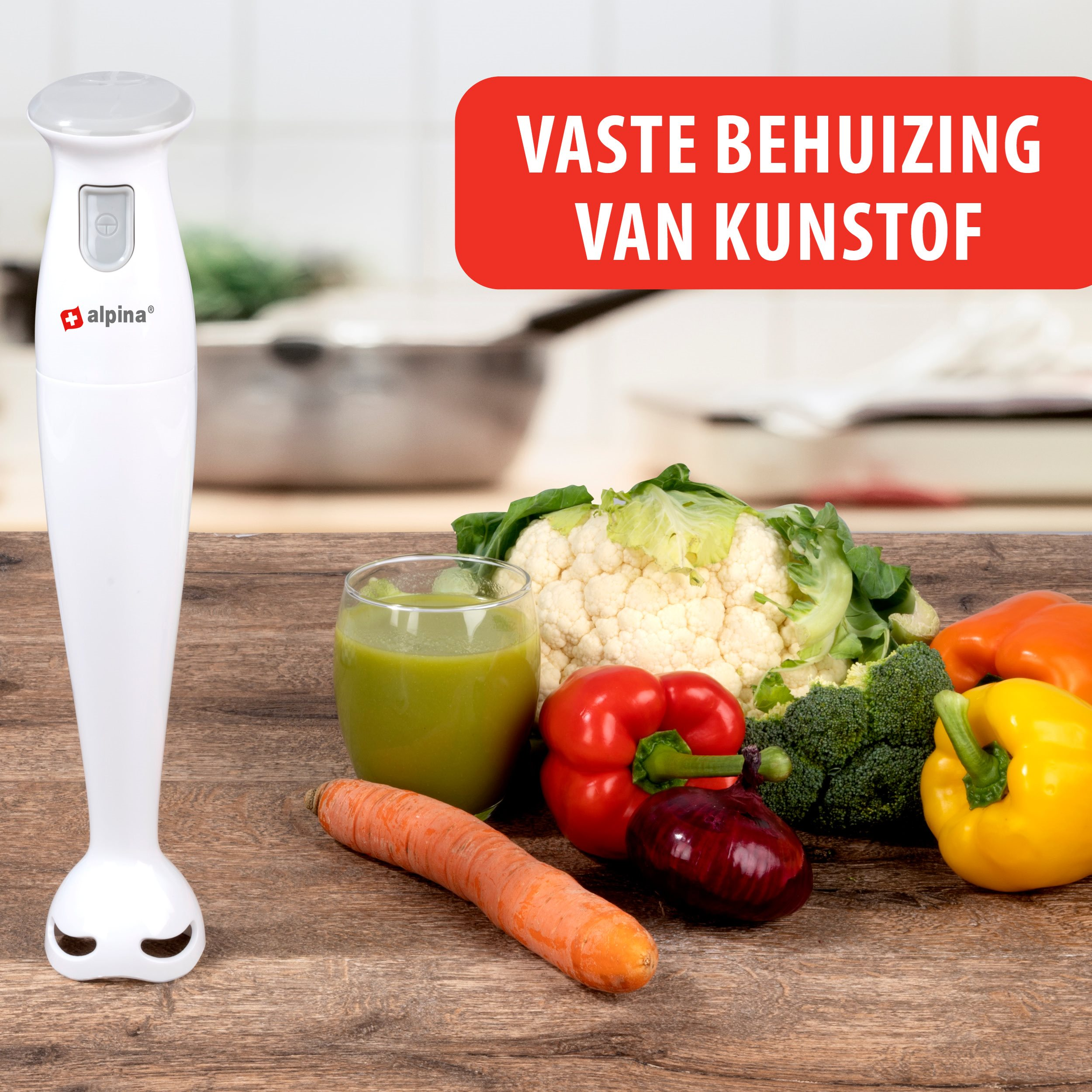 Weißer Handmixer mit Gemüse auf Holztisch. Roter Text lautet 'VASTE BEHUIZING VAN KUNSTOF'.
