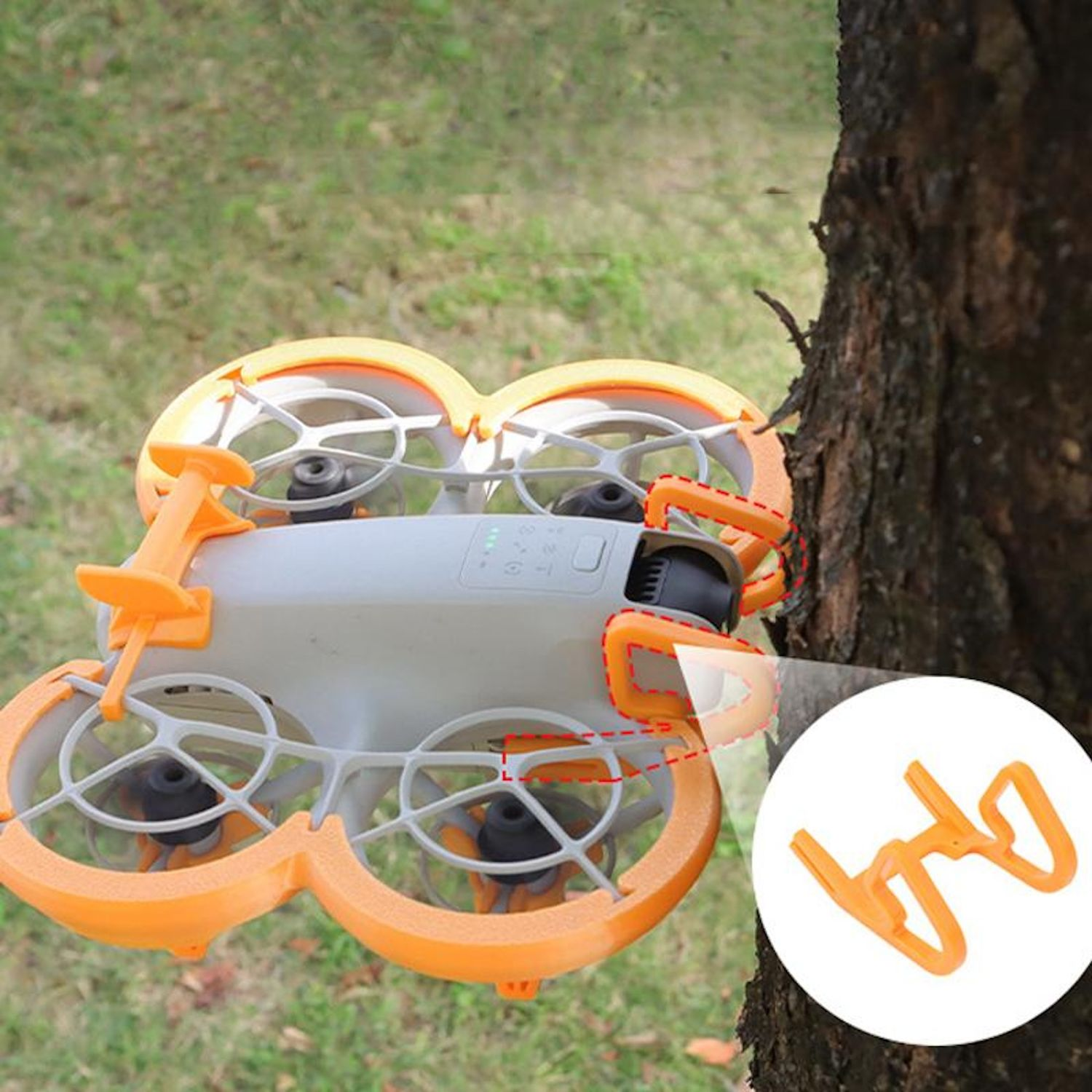 Un drone bianco e arancione vicino a un albero con una parte di protezione arancione.